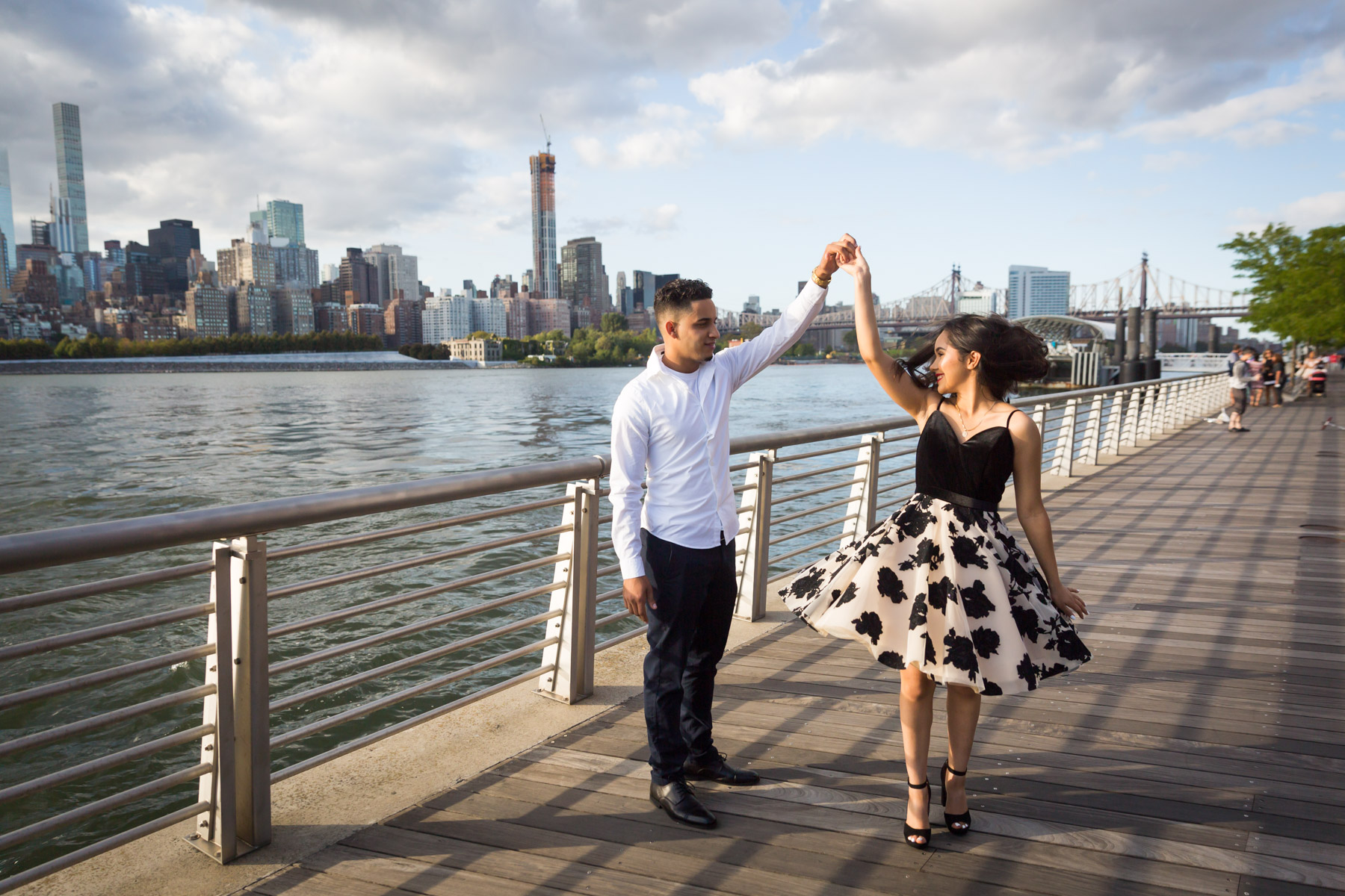 Couple dancing on boardwalk with city skyline in background for an article on how to beat the summer heat during a photo shoot