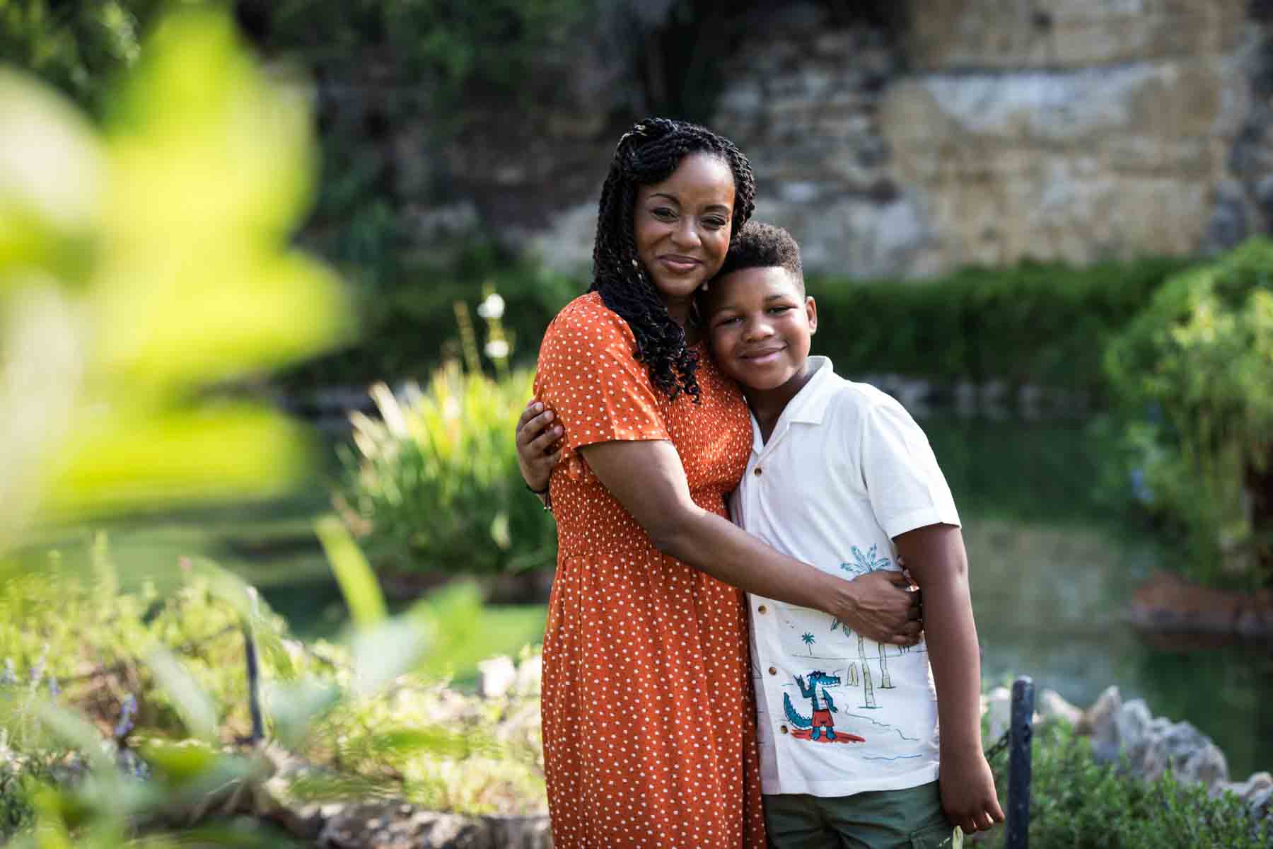 African American mother and son hugging in the San Antonio Japanese Tea Garden during a photo shoot