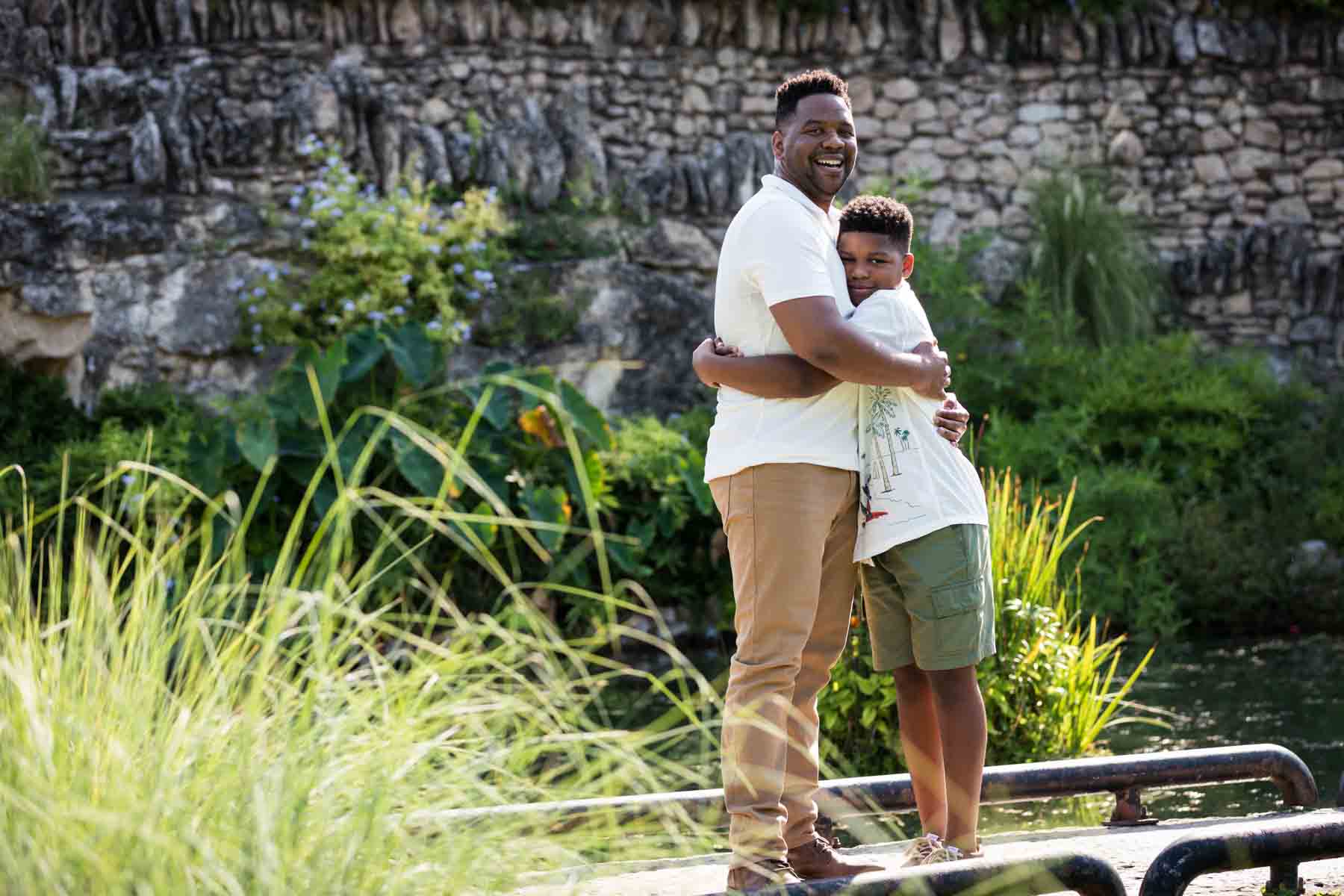 Japanese Tea Garden family portrait of an African American father and son hugging on a bridge over a pond