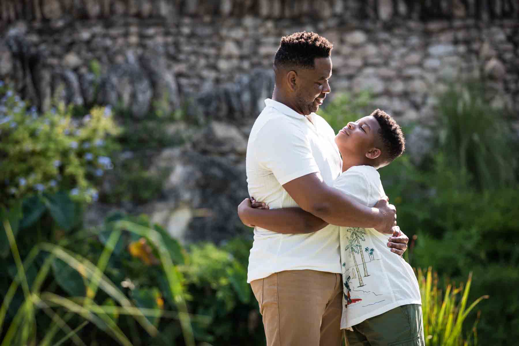 Japanese Tea Garden family portrait of an African American father and son hugging on a bridge over a pond