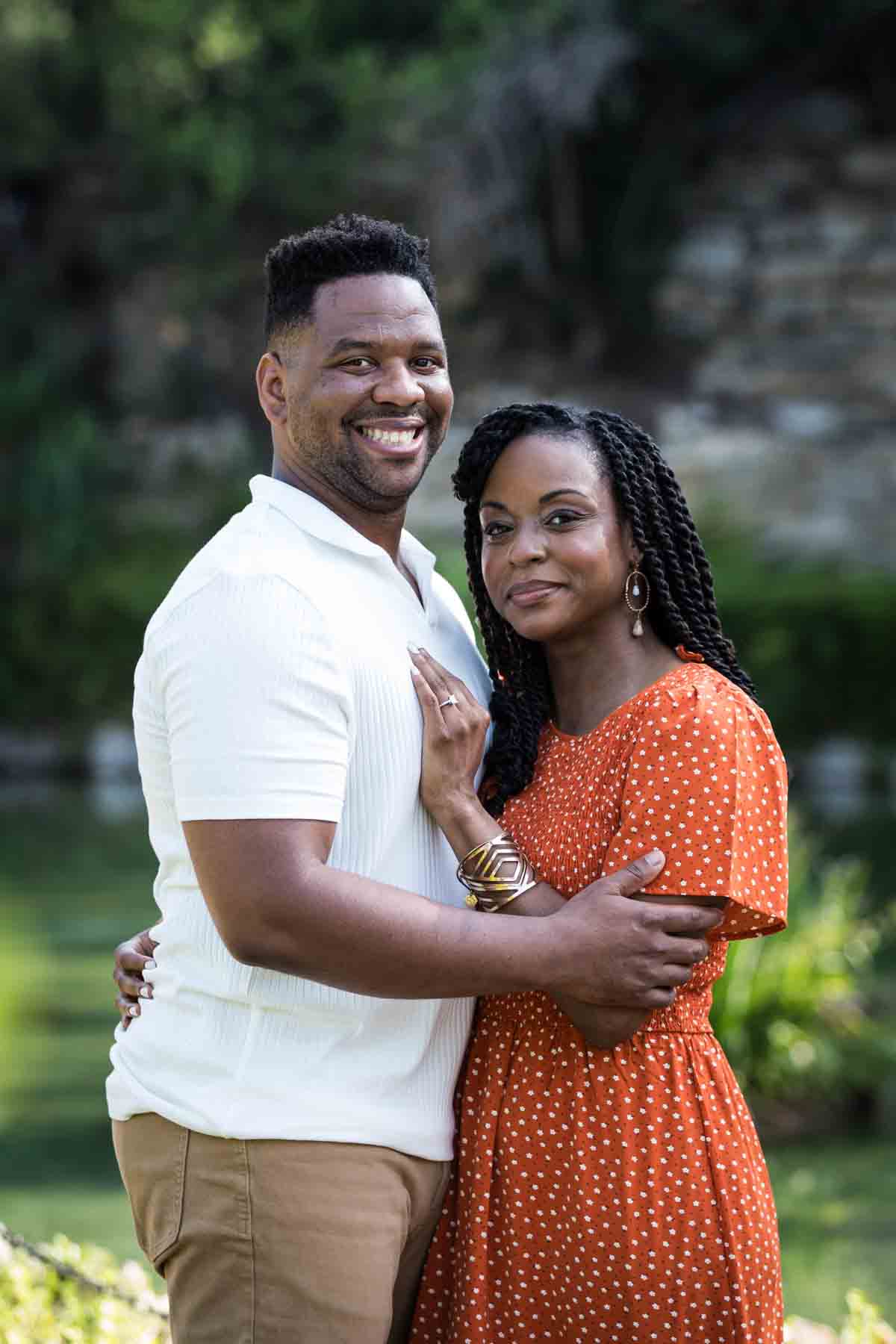 African American man and woman hugging in front of a pond during a Japanese Tea Garden engagement portrait