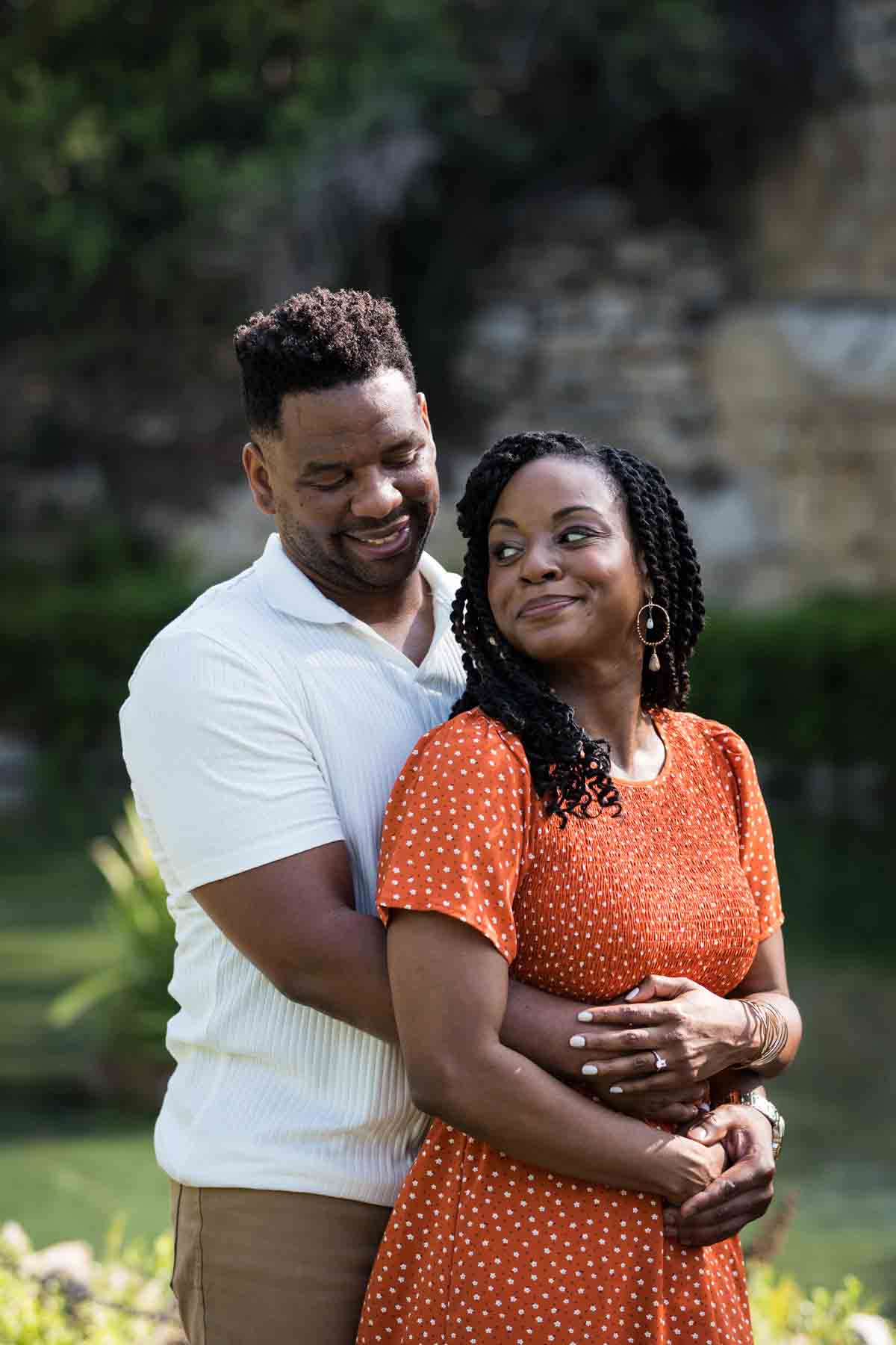 African American man and woman hugging in front of a pond during a Japanese Tea Garden engagement portrait