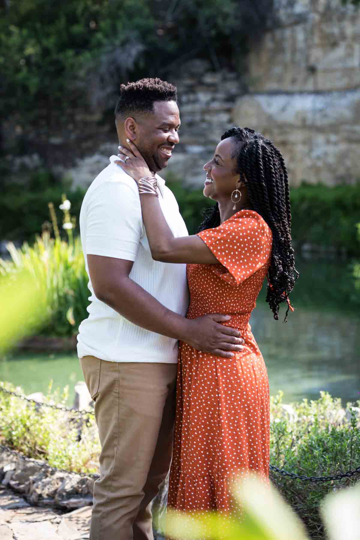 African American man and woman hugging in front of a pond during a Japanese Tea Garden engagement portrait