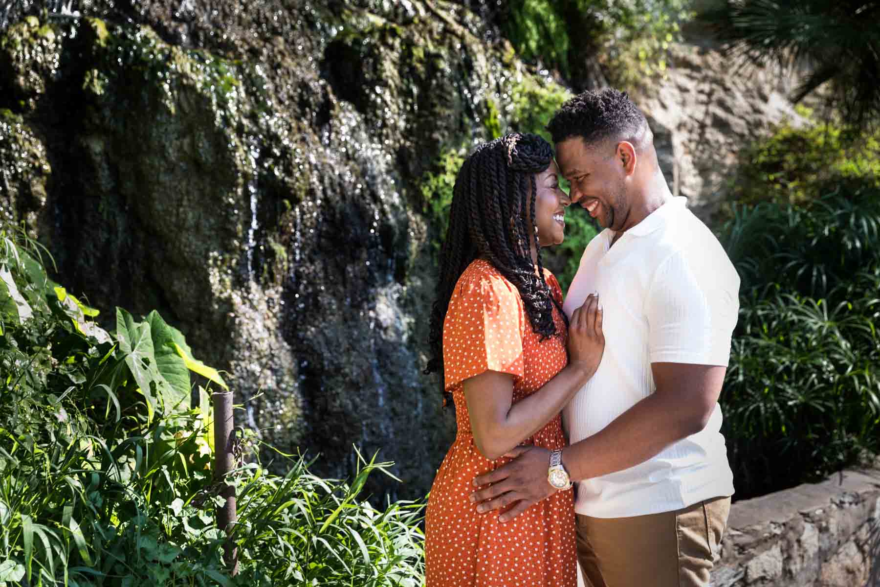 Japanese Tea Garden family portrait of an African American couple standing with foreheads touching in front of a waterfall