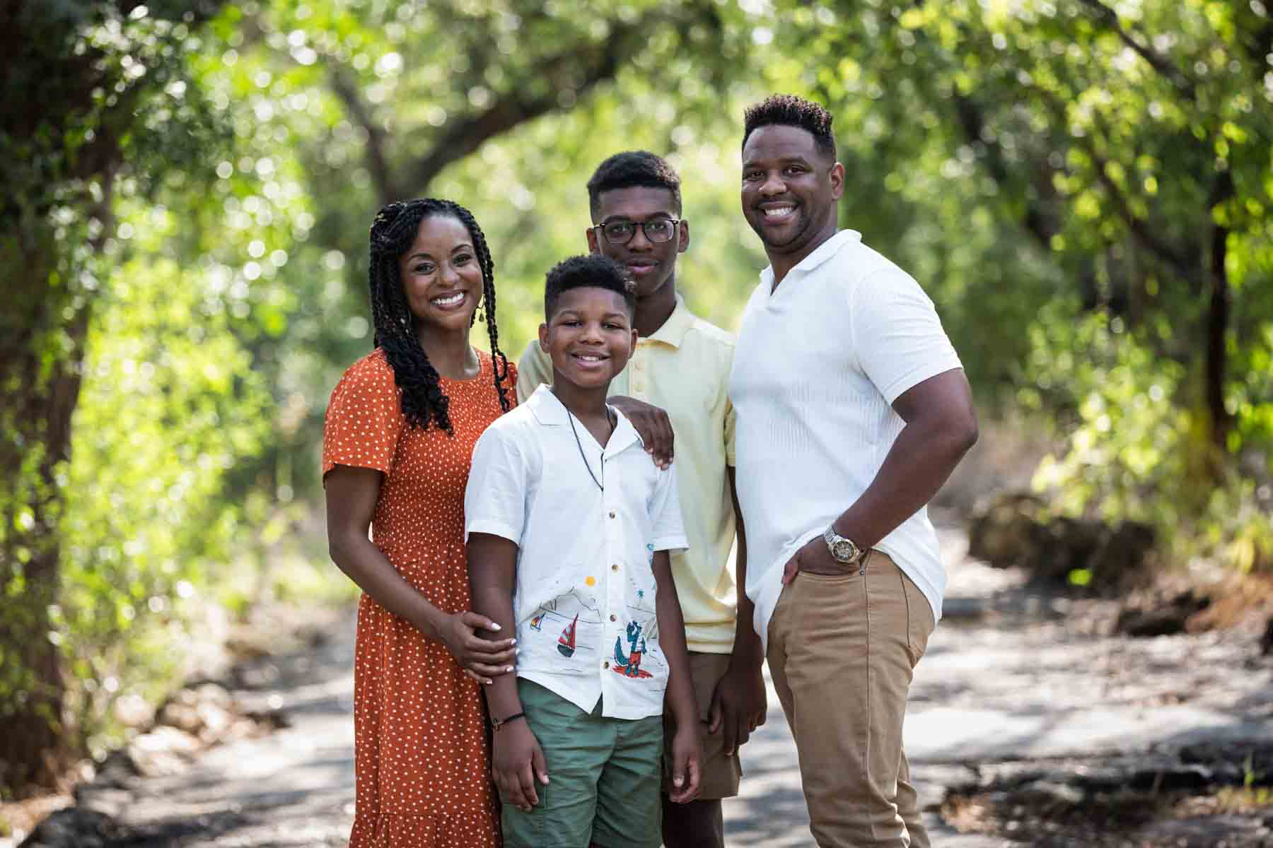 African American family of mother, father, and two sons standing in a forest for a Japanese Tea Garden family photo shoot