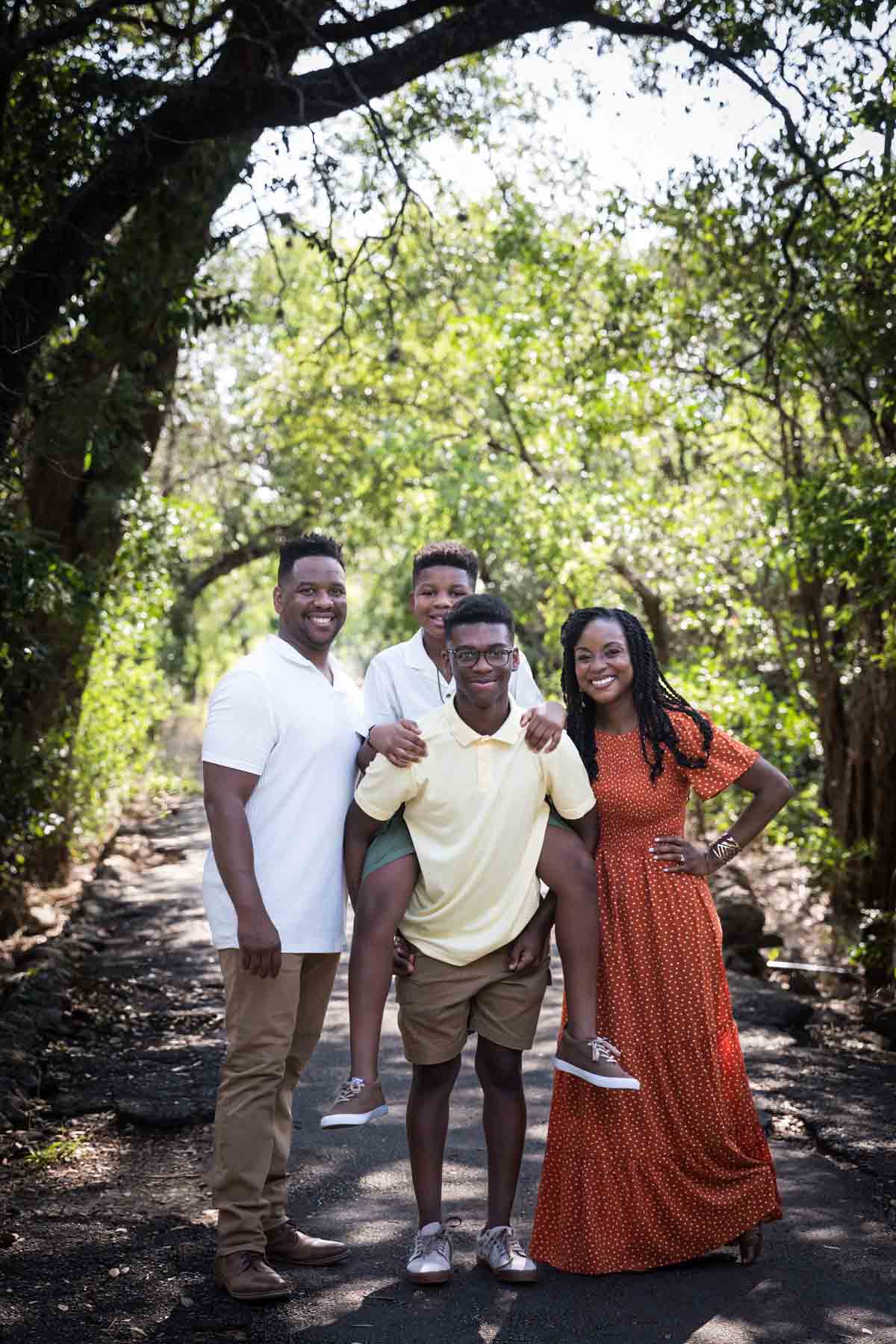 African American family of mother, father, and two sons standing in a forest for a Japanese Tea Garden family photo shoot