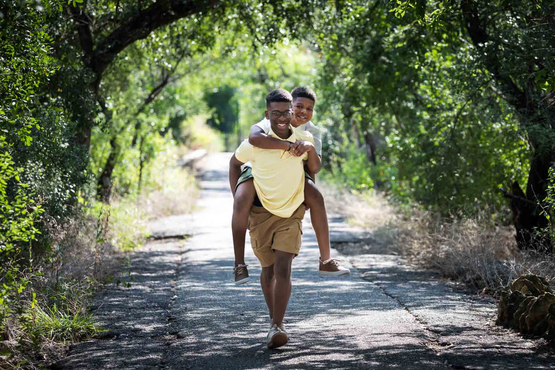 Japanese Tea Garden family portrait of an African American boy carrying his younger brother in a piggy back through the forest