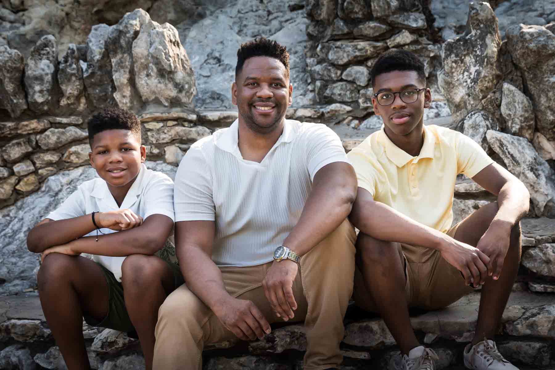 African American father and his two sons sitting on stone steps during a Japanese Tea Garden family photo shoot