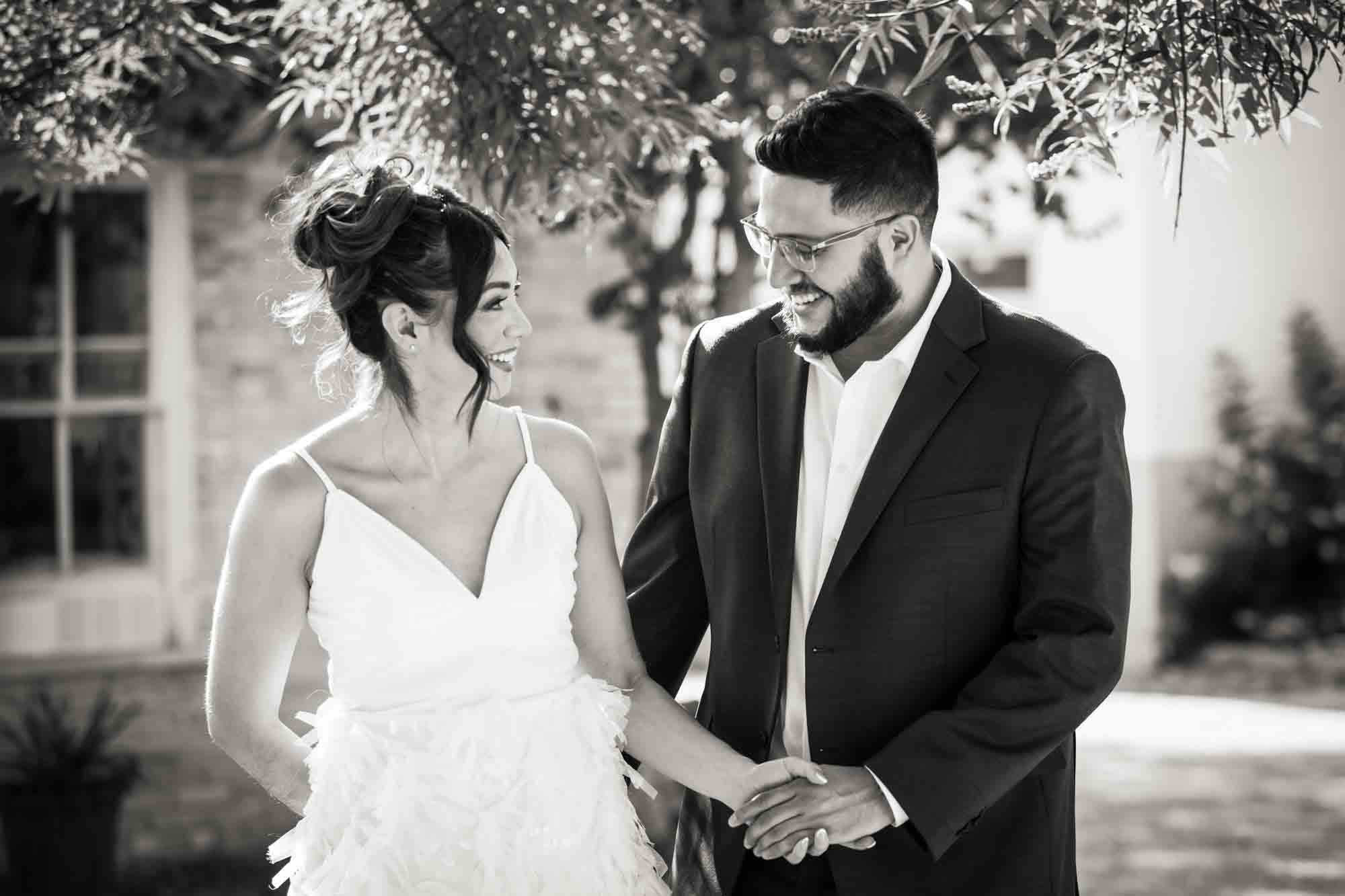 Black and white La Villita engagement photos of man looking at woman wearing white dress