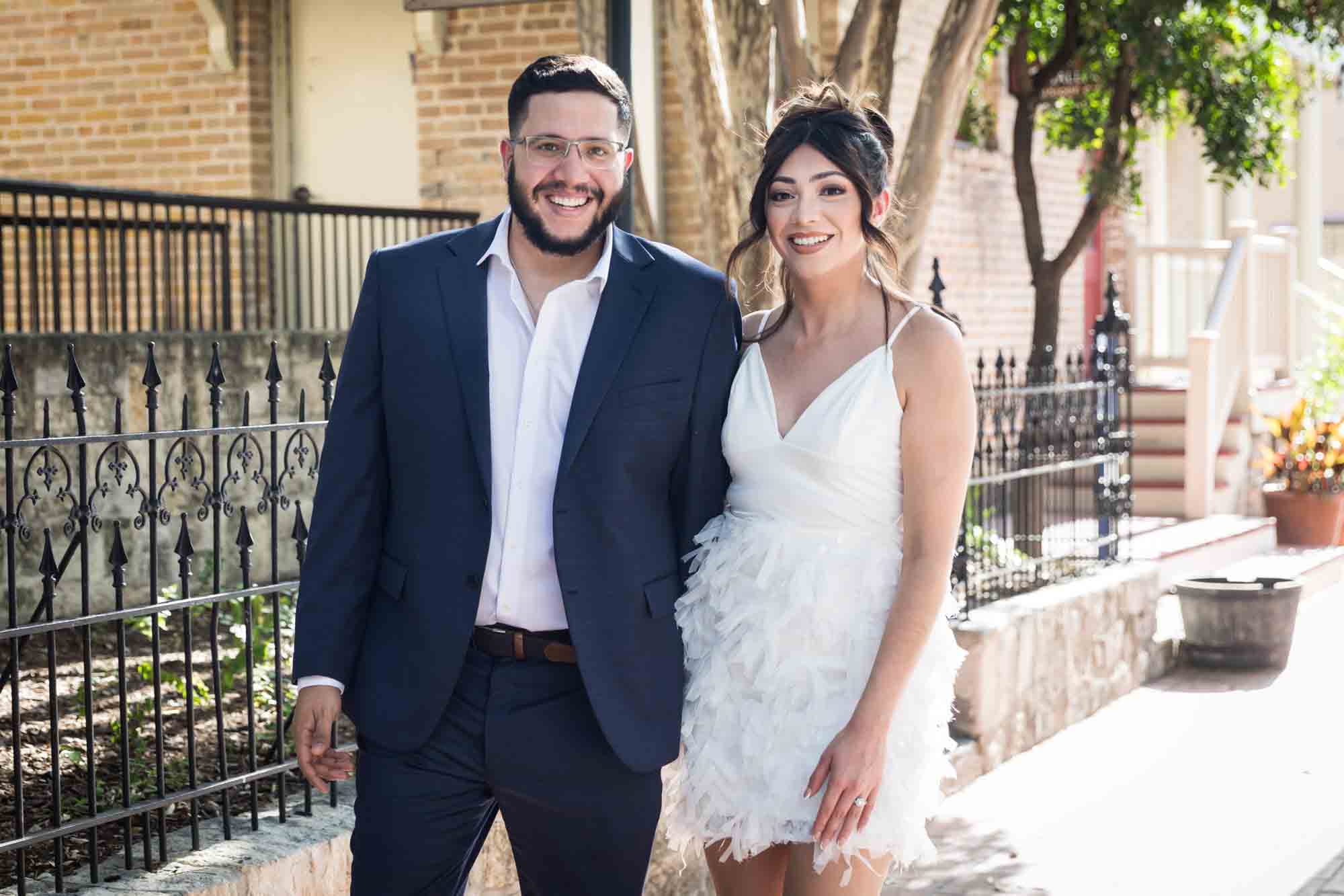 La Villita engagement photos of couple holding hands and walking on sidewalk