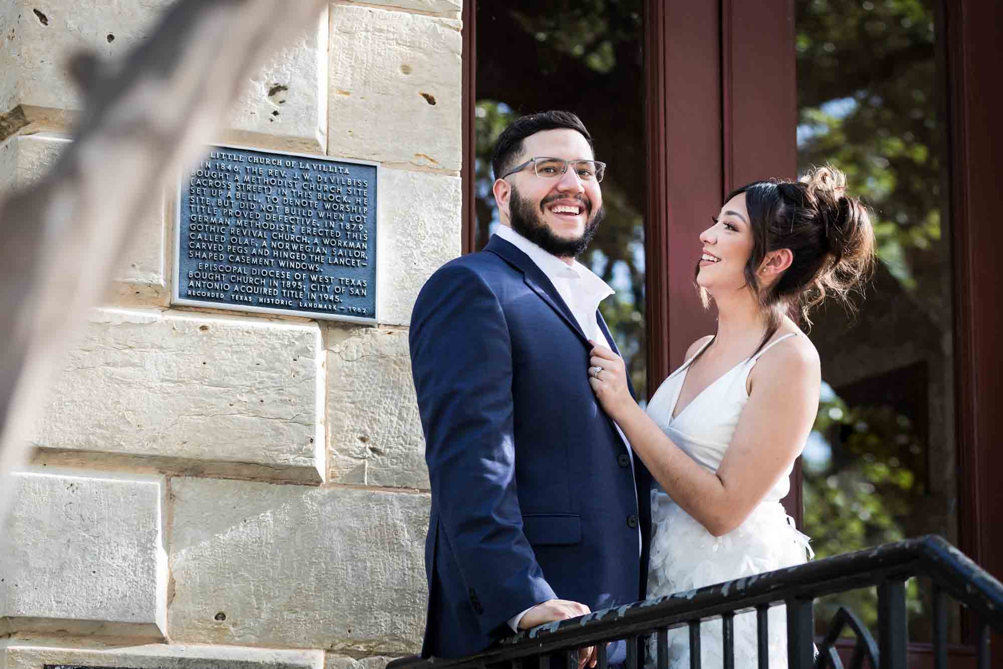 La Villita engagement photos of couple hugging against stair railing