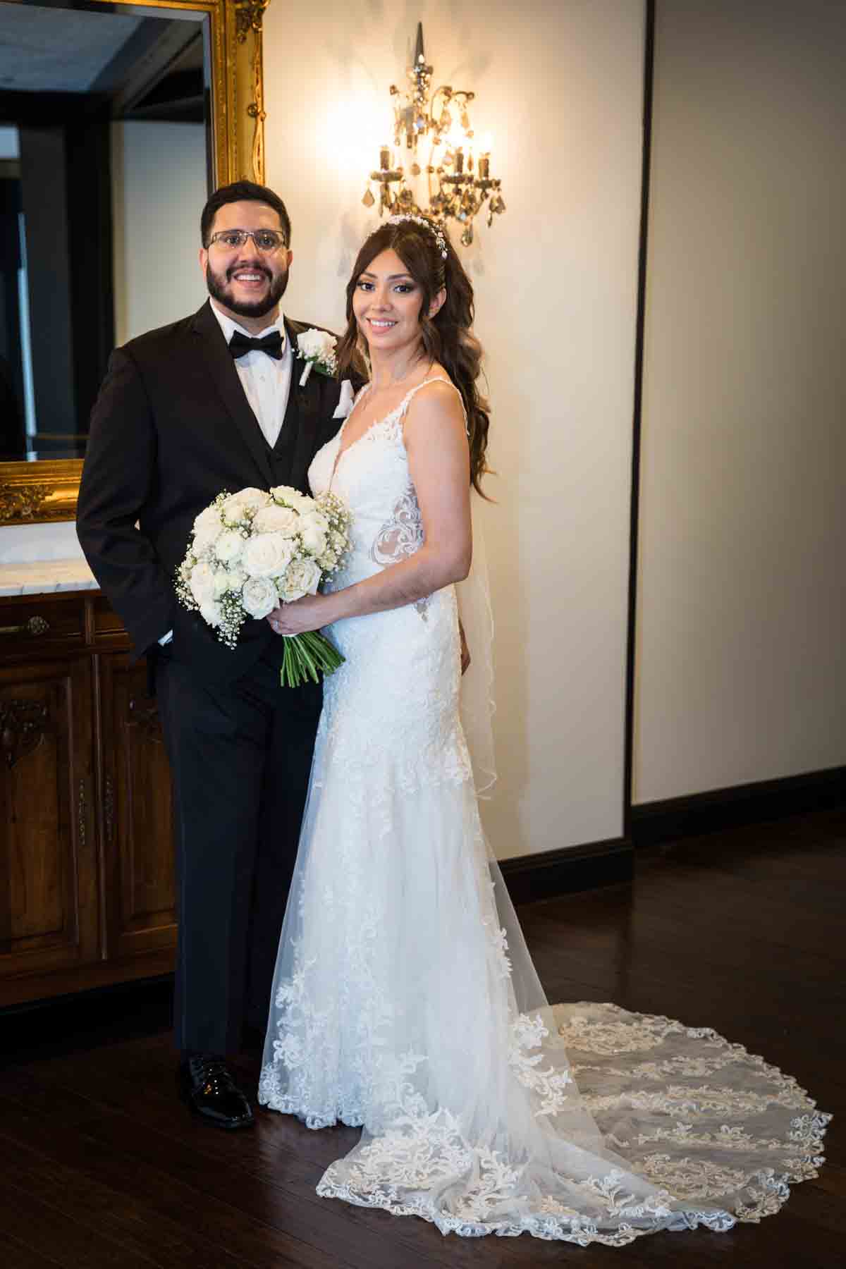 Bride and groom hugging in front of gold mirror and sconce at an Old San Francisco Steakhouse wedding