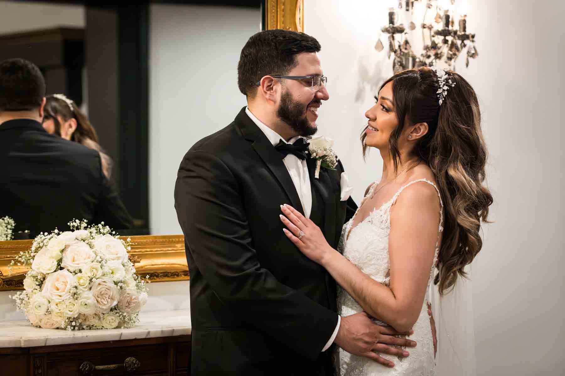 Bride and groom hugging in front of gold mirror and sconce at an Old San Francisco Steakhouse wedding