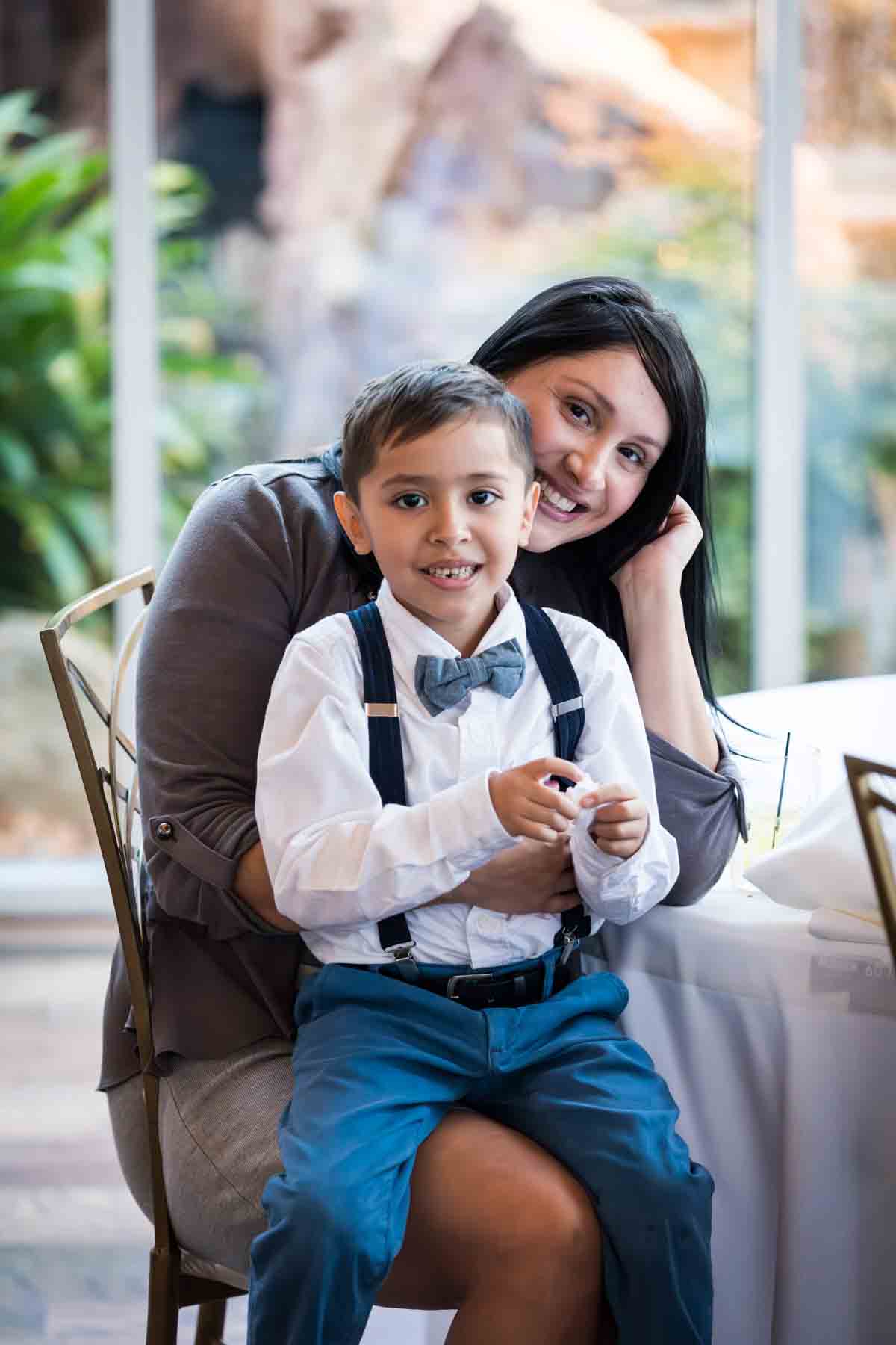 Woman with little boy wearing bow tie on her lap at an Old San Francisco Steakhouse wedding