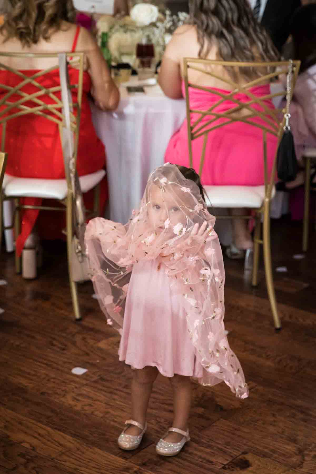 Little girl standing with pink dress over her head at an Old San Francisco Steakhouse wedding