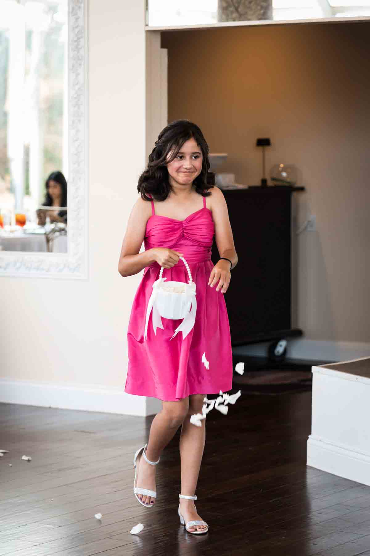 Girl wearing pink dress dropping flower petals during ceremony at an Old San Francisco Steakhouse wedding