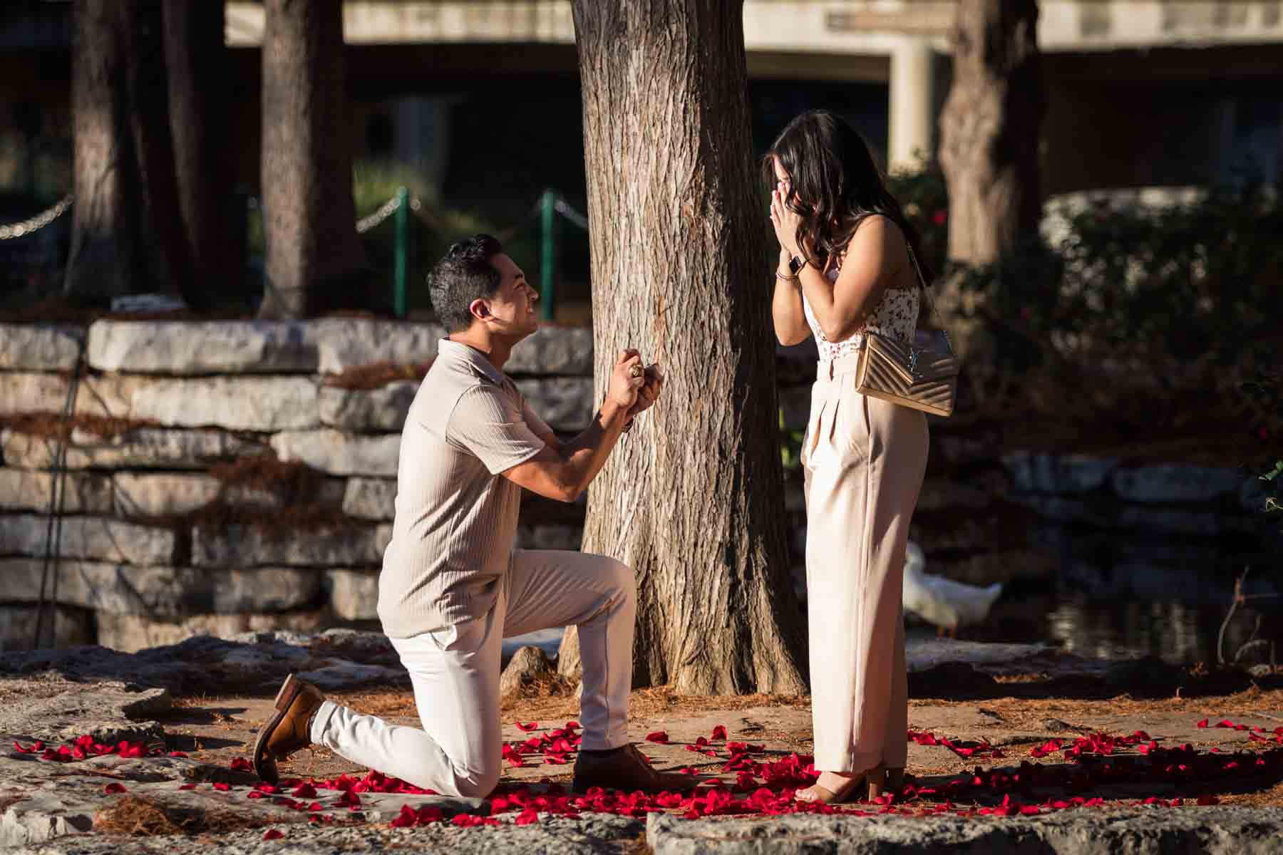 Man on one knee extending engagement ring in front of woman crying at the Pearl for an article listing the best places to propose in San Antonio