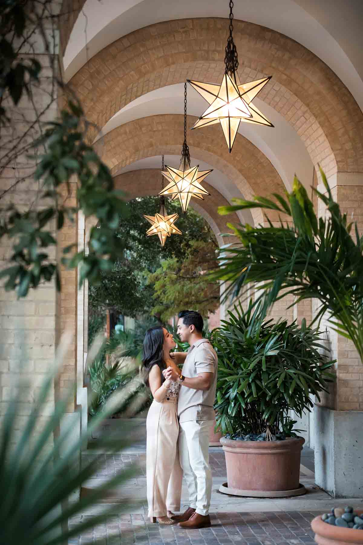 Couple dancing under brick canopy with star-shaped lights overhead