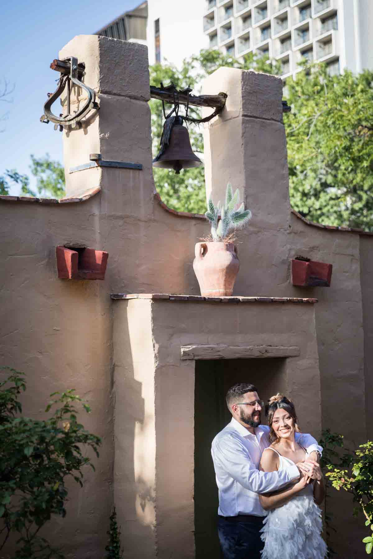 Couple hugging in front of adobe-style building at La Villita