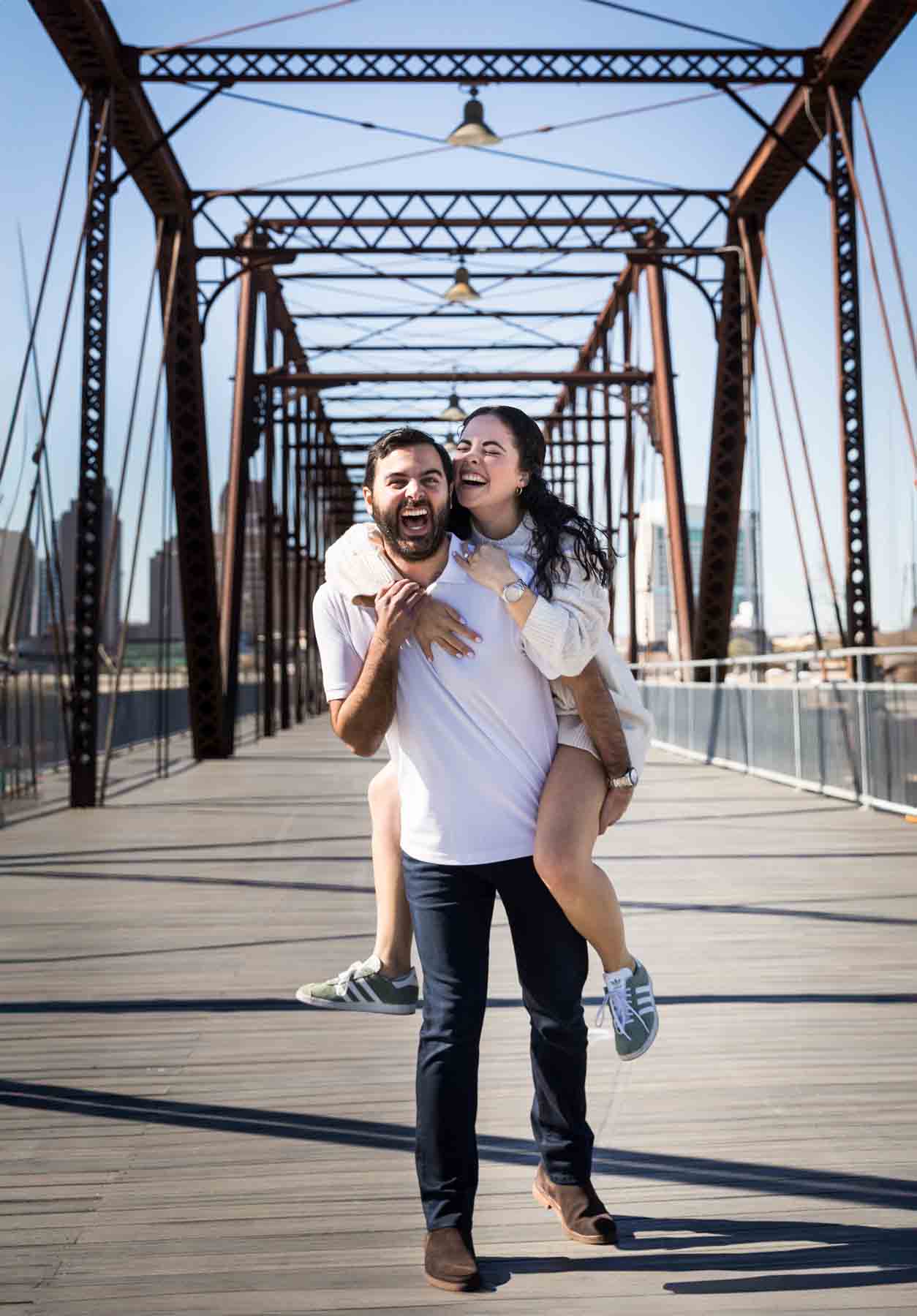 Man giving woman a piggyback ride on the Hays Street Bridge after a proposal