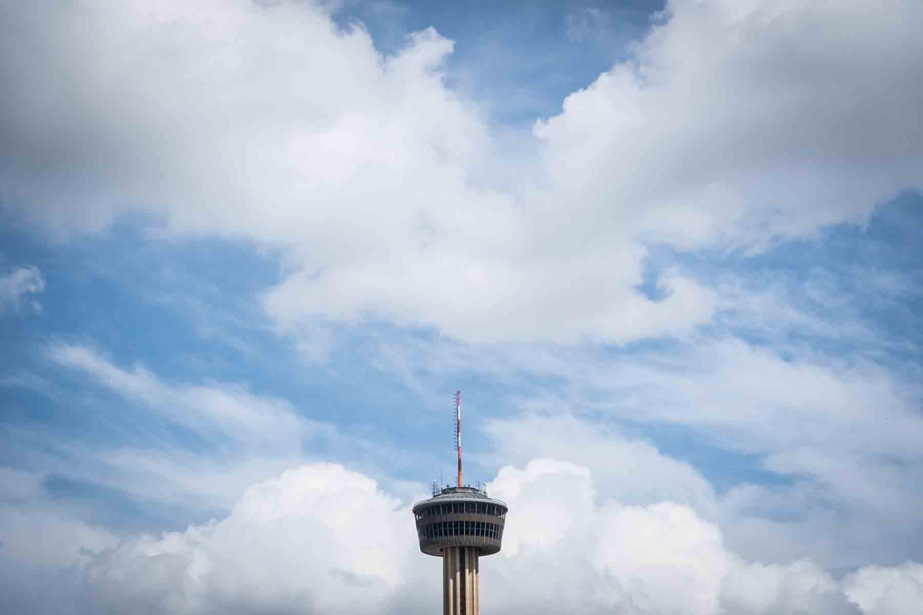 Tower of the Americas top against a blue sky with clouds for an article listing the best places to propose in San Antonio