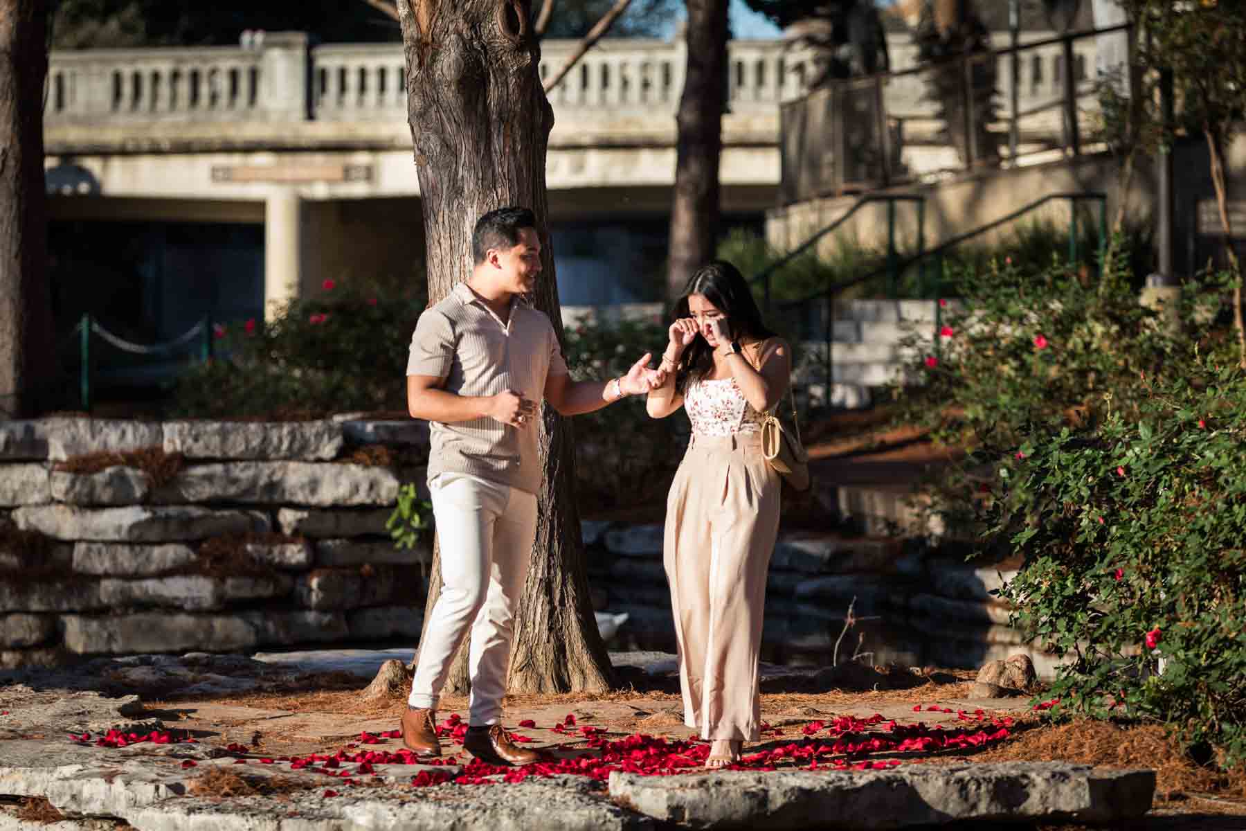 Man and woman standing on River Walk island at the Pearl after a surprise proposal