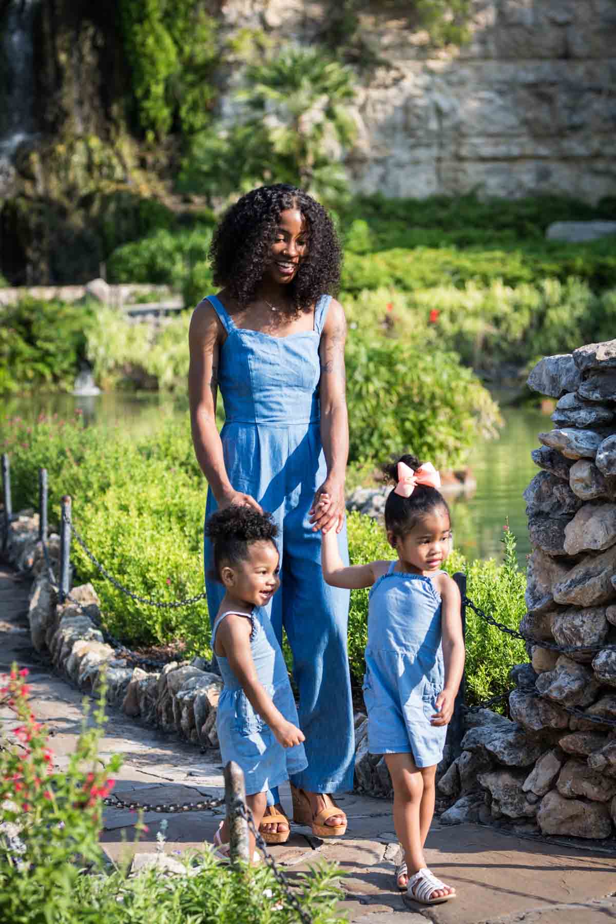 African American mother walking with her two adorable daughters in the pathway of the Japanese Tea Garden in front of a pond for an article on 'How often should I take family photos?'