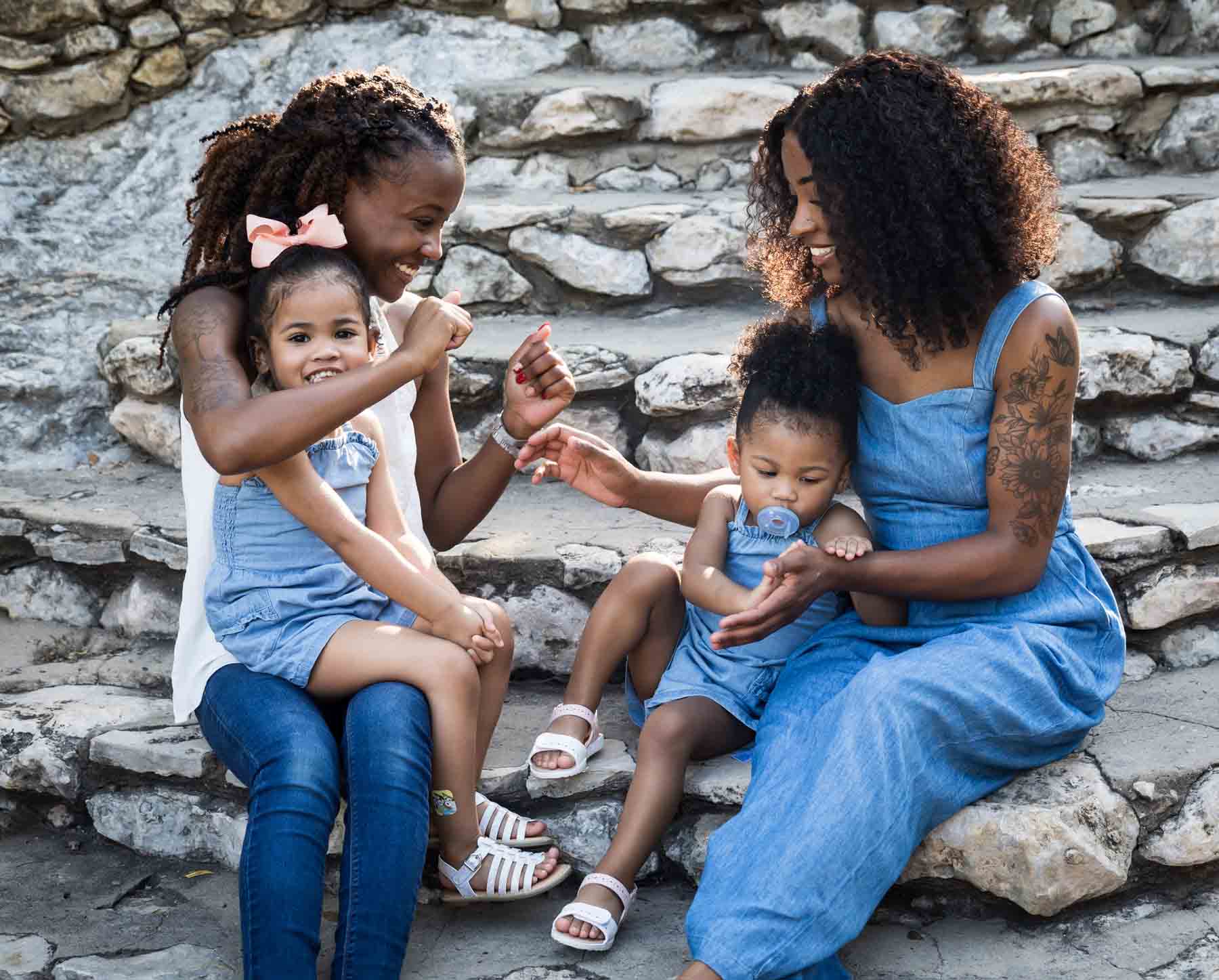 African American sisters and two little girls playing on stone staircase at the Japanese Tea Garden for an article on 'How often should I take family photos?'