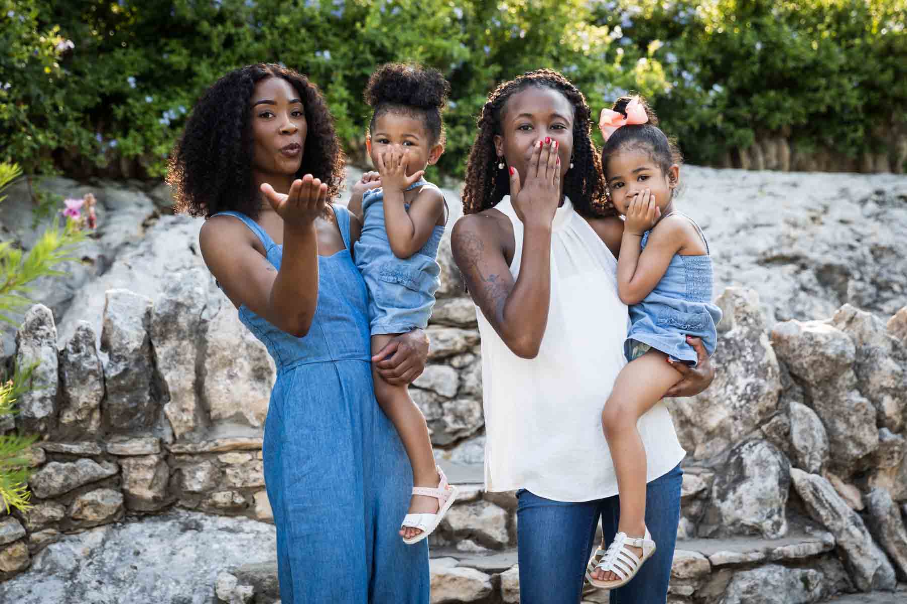 African American sisters and two little girls blowing kisses in front of stone staircase at the Japanese Tea Garden for an article on 'How often should I take family photos?'