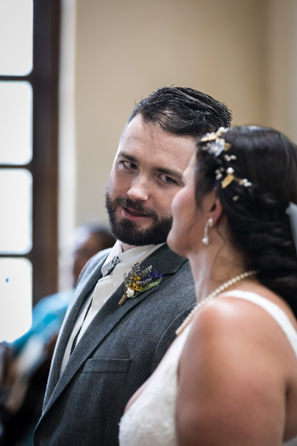 Groom turning to bride to speak during ceremony for an article on how to get married at Mission Espada