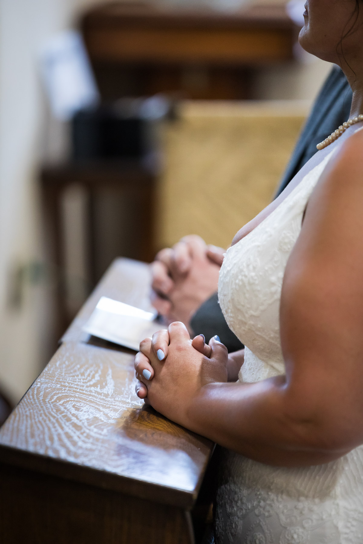 Close up of bride and groom clasping hands during ceremony