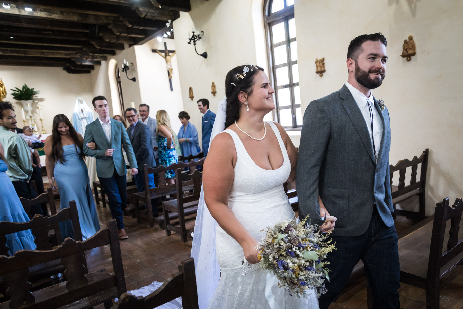 Bride and groom exiting church after ceremony for an article on how to get married at Mission Espada