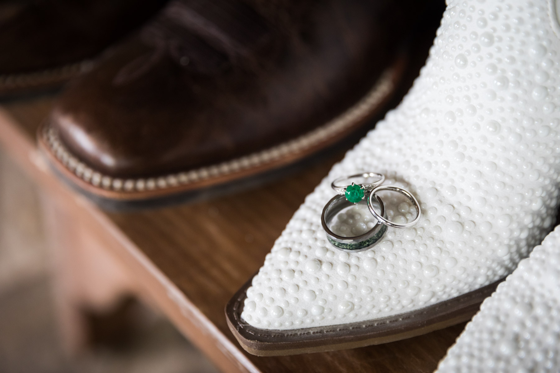 Close up of wedding rings on top of white cowboy boots