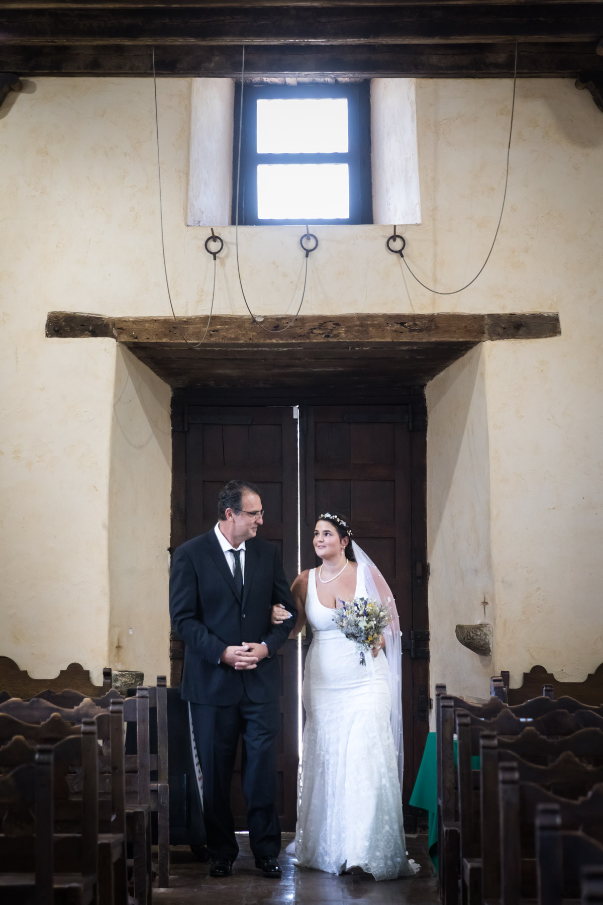 Bride and father in doorway of Mission Espada church for an article on how to get married at Mission Espada