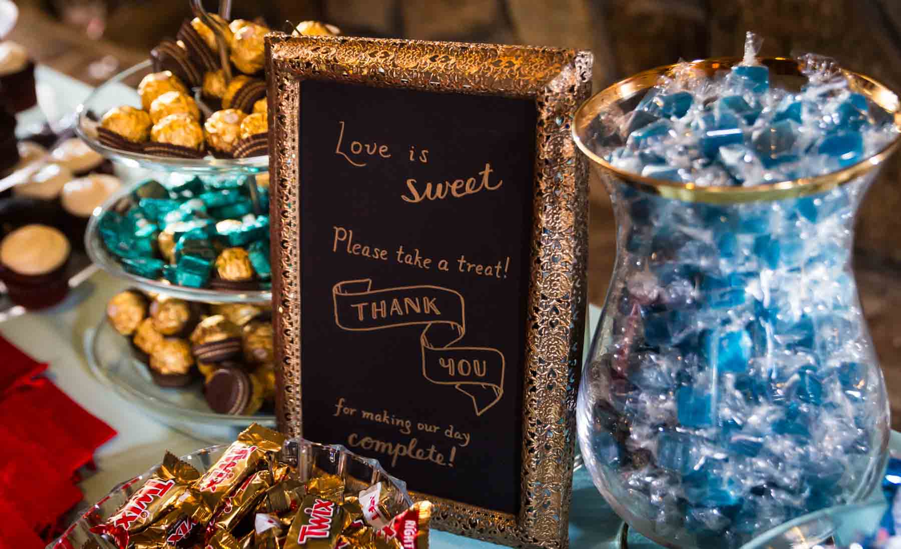 Close up of candy table with sign set for guests after wedding for an article on how to have an eco-friendly wedding