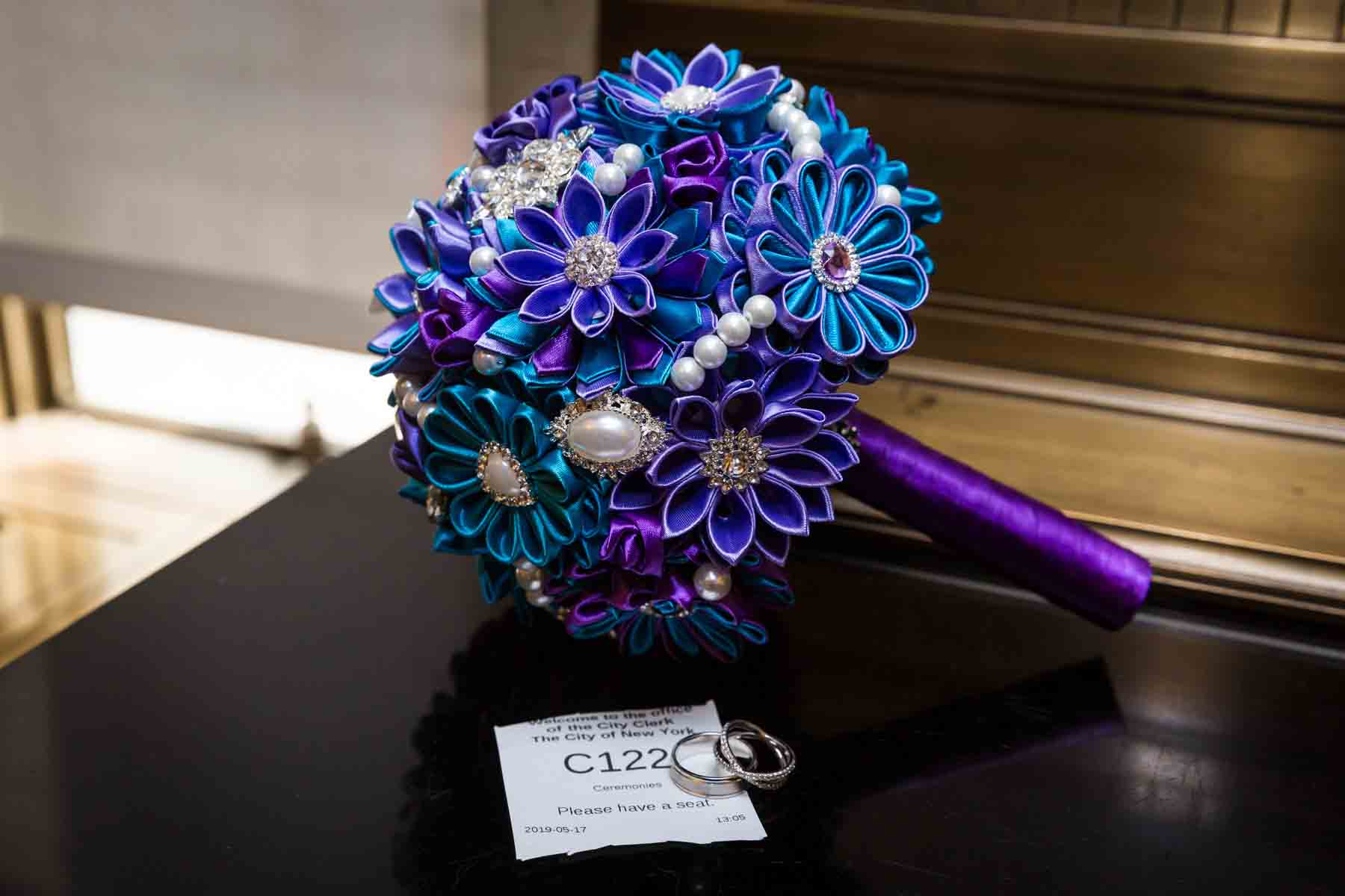 Close up on purple and blue bridal bouquet made of fabric and brooches for an article on how to have an eco-friendly wedding