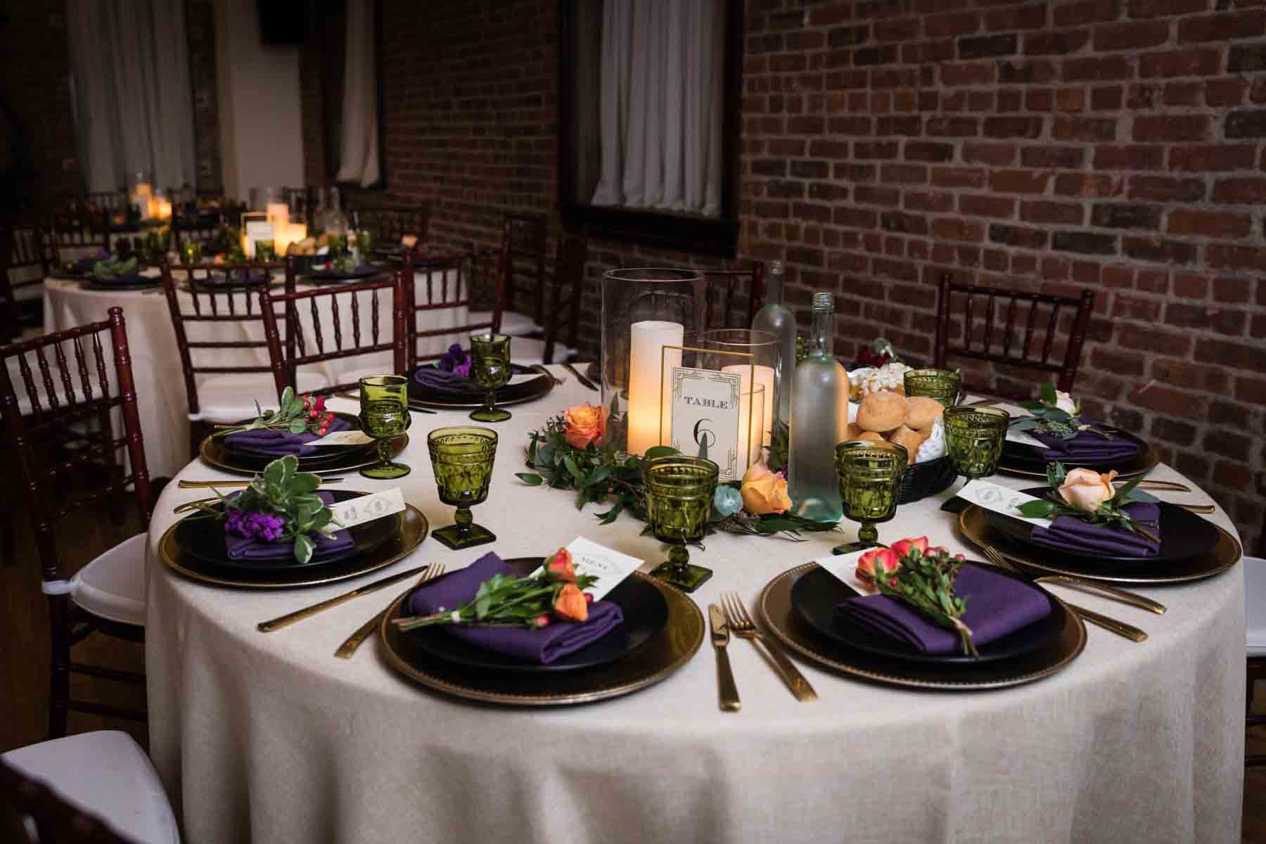 Table set with gold chargers and minimal flowers and candles