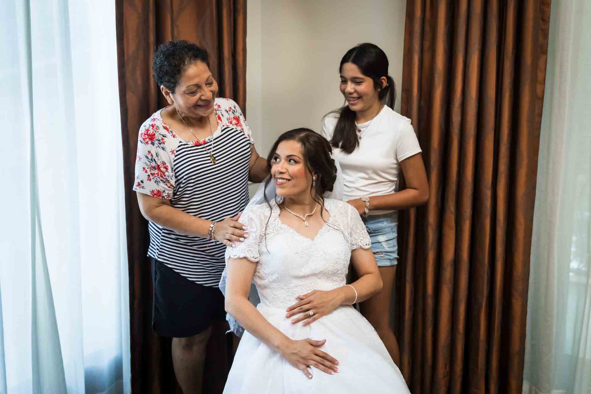 Bride seated with older woman and young girl behind her during a Hotel Contessa bridal portrait session in downtown San Antonio