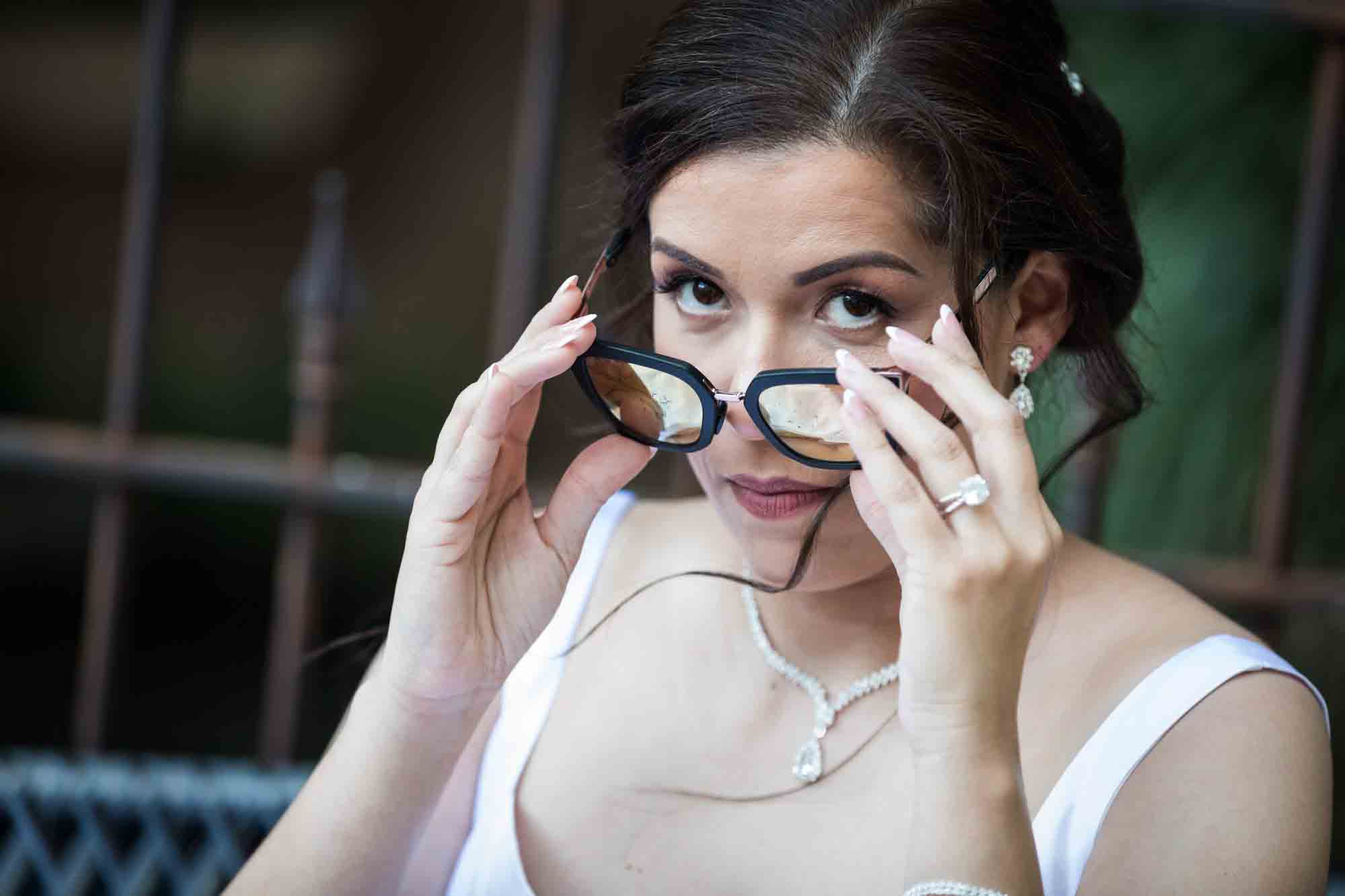 Bride looking into camera from behind sunglasses during a downtown San Antonio bridal portrait session