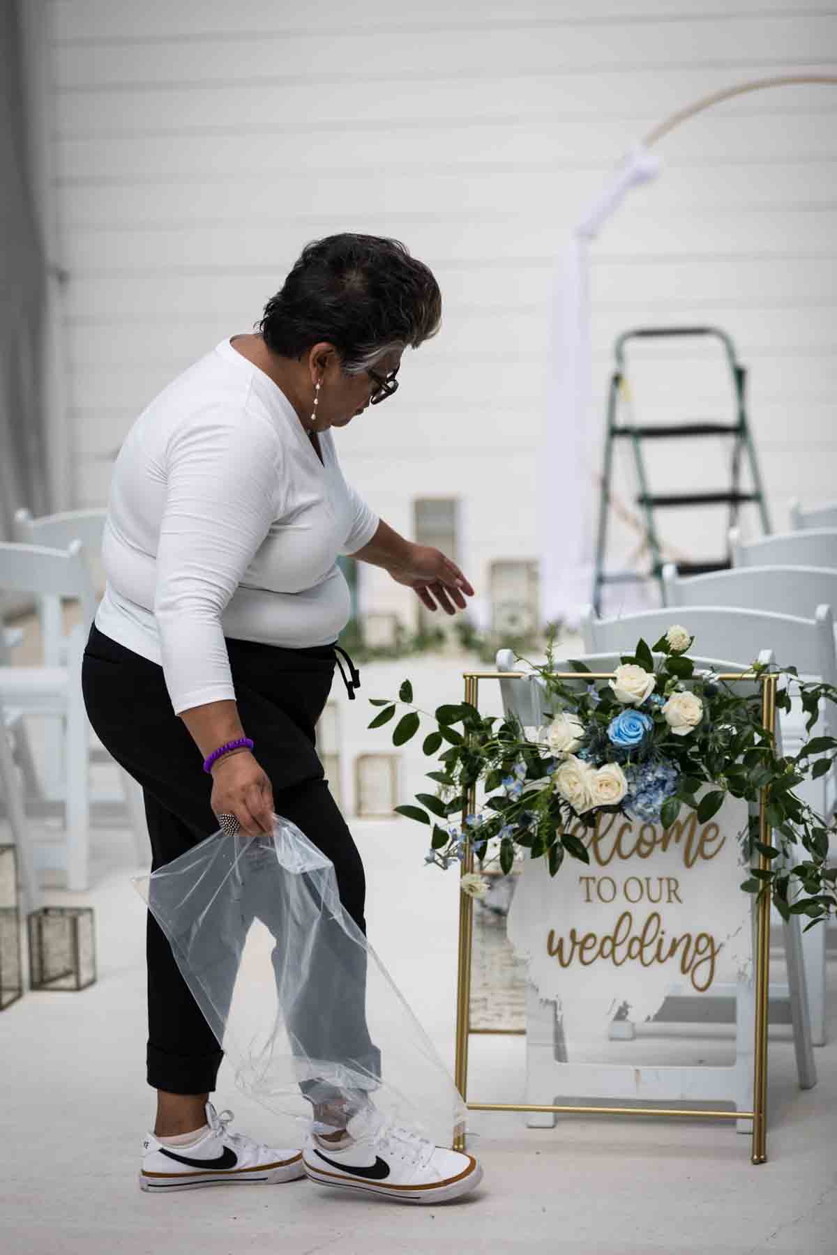 Cici of Ay Poppy! inspecting a 'Welcome to Our Wedding' sign for an article on how to choose the perfect flowers for your wedding or event