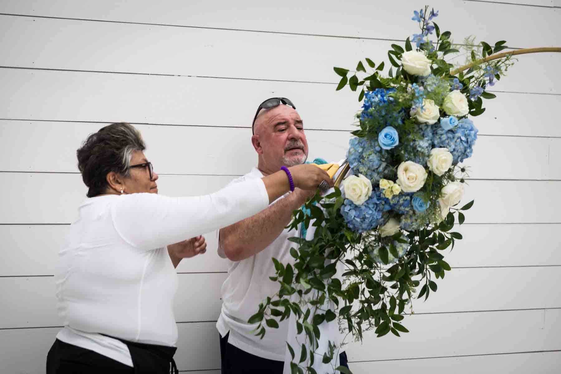 Floral team at Ay Poppy! putting together a white and blue floral arrangement for an article on how to choose the perfect flowers for your wedding or event