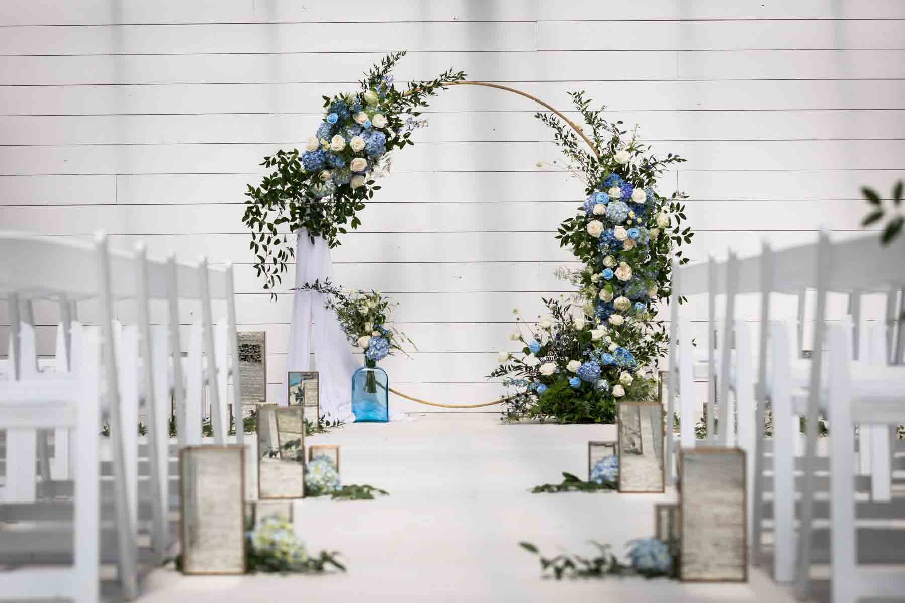 Finished white and blue wedding ceremony floral display with aisle decorations for an article on how to choose the perfect flowers for your wedding or event