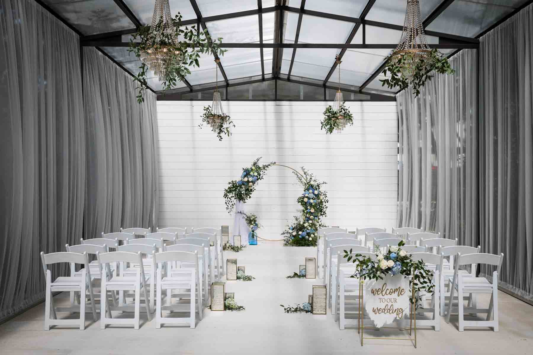 Finished white and blue wedding ceremony floral display with aisle decorations for an article on how to choose the perfect flowers for your wedding or event