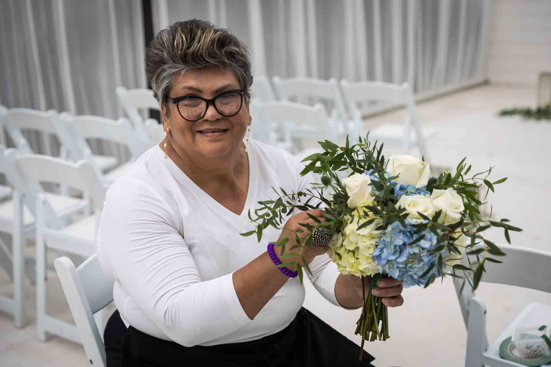 Cici of Ay Poppy! Floral and Event Decor holding a white and blue bridal bouquet for an article on how to choose the perfect flowers for your wedding or event