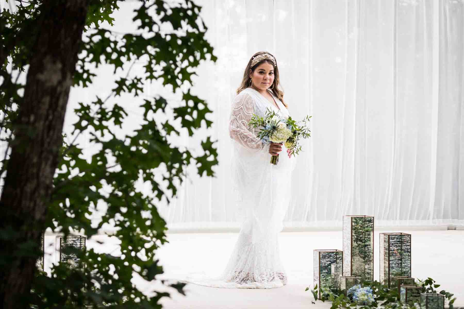 Bride with long sleeves holding a white and blue bridal bouquet for an article on how to choose the perfect flowers for your wedding or event