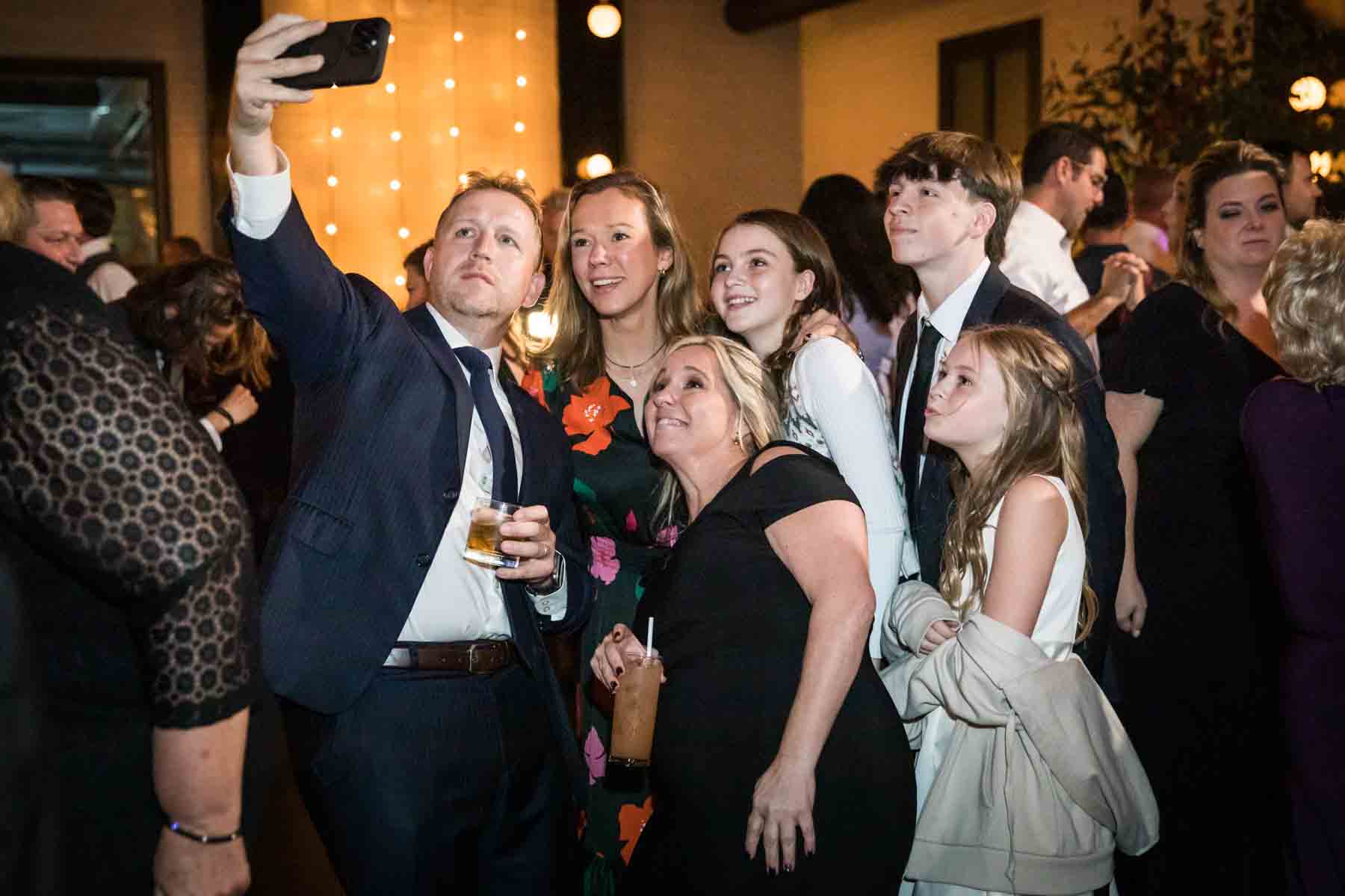 Group of guests taking a selfie at a wedding reception for an article on how to take the perfect selfie