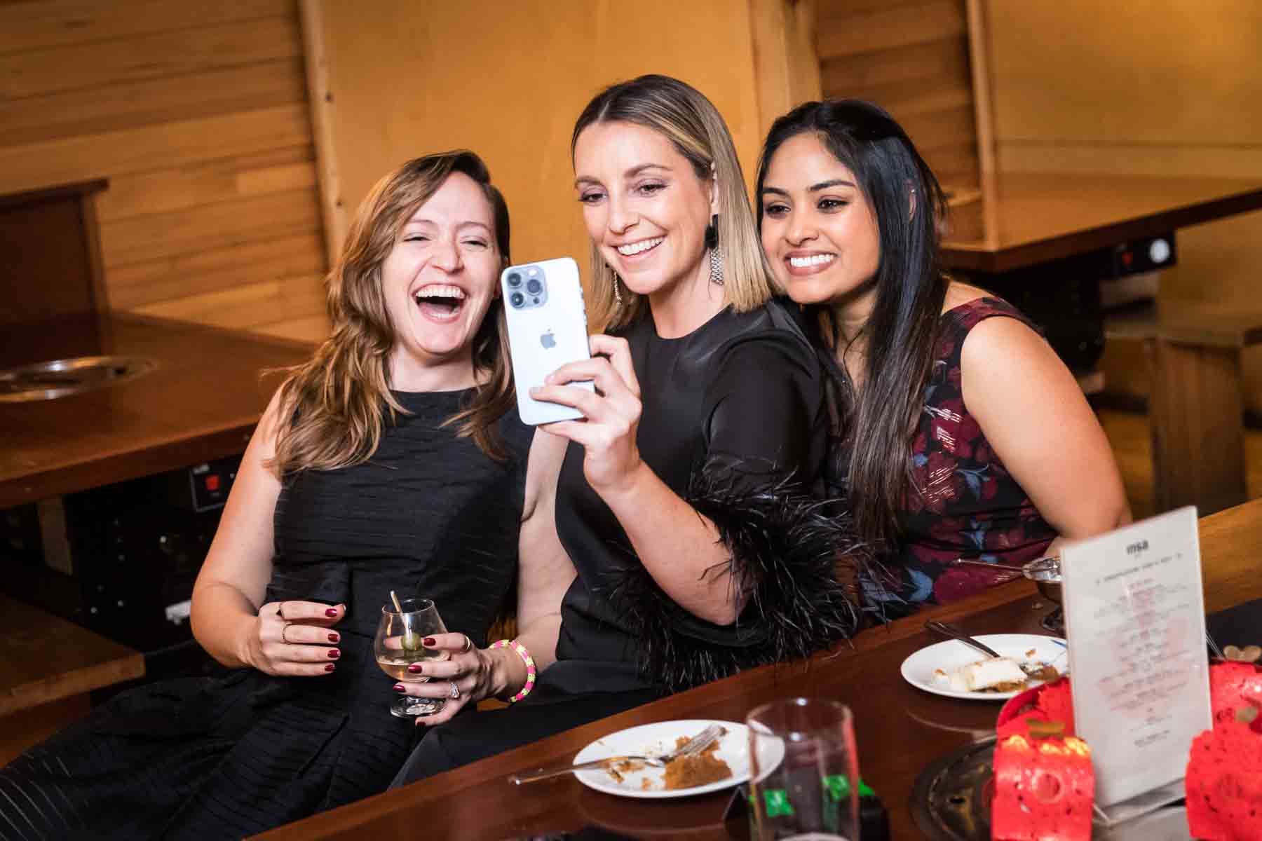 Three female guests taking a selfie at a wedding reception for an article on how to take the perfect selfie