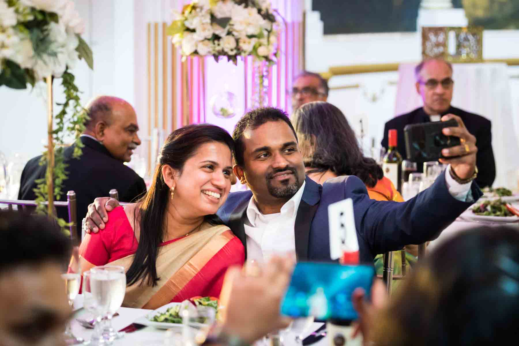 Two Indian guests taking a selfie at a wedding reception for an article on how to take the perfect selfie