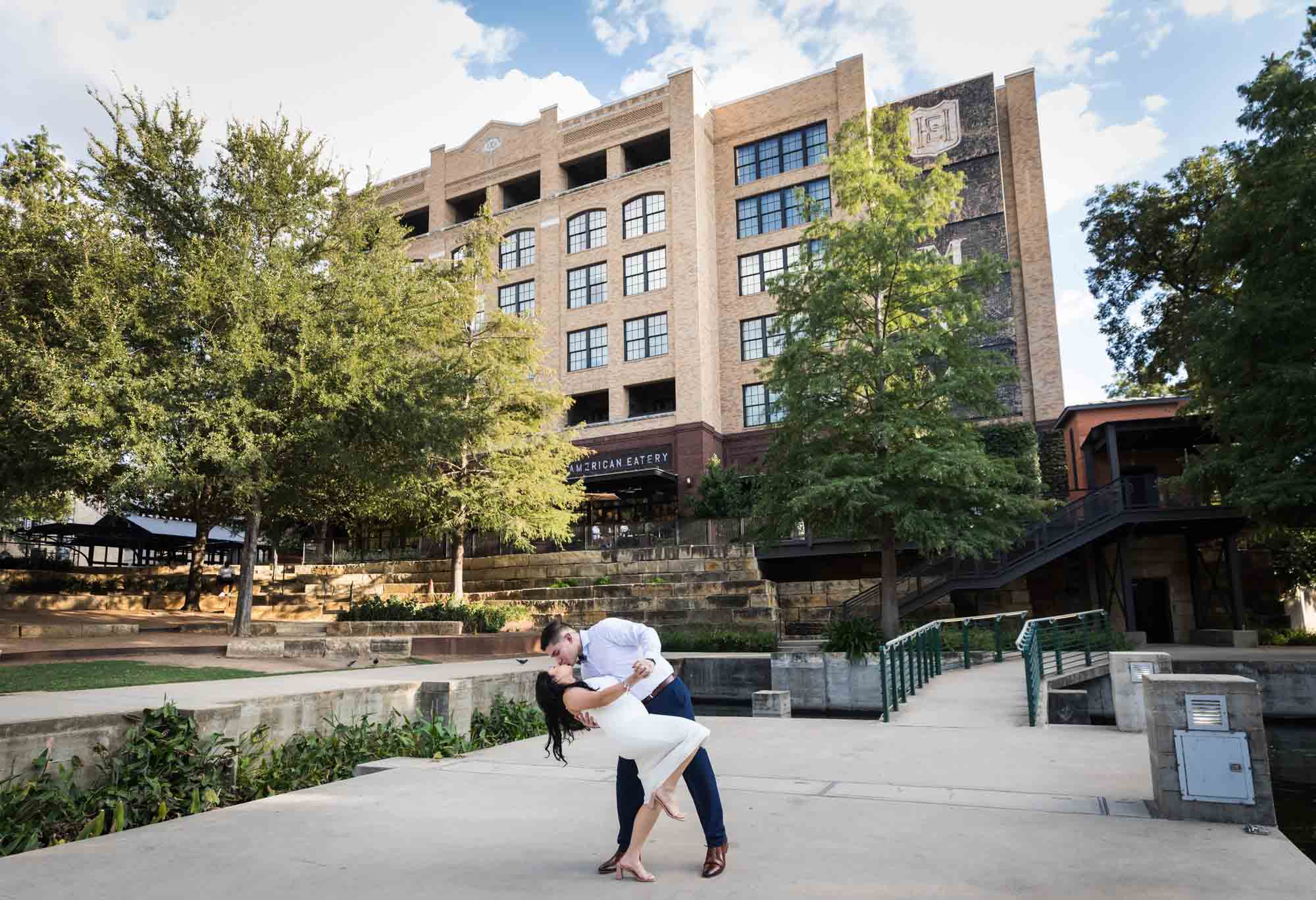 Man dipping woman while dancing on patio in front of Hotel Emma at the Pearl