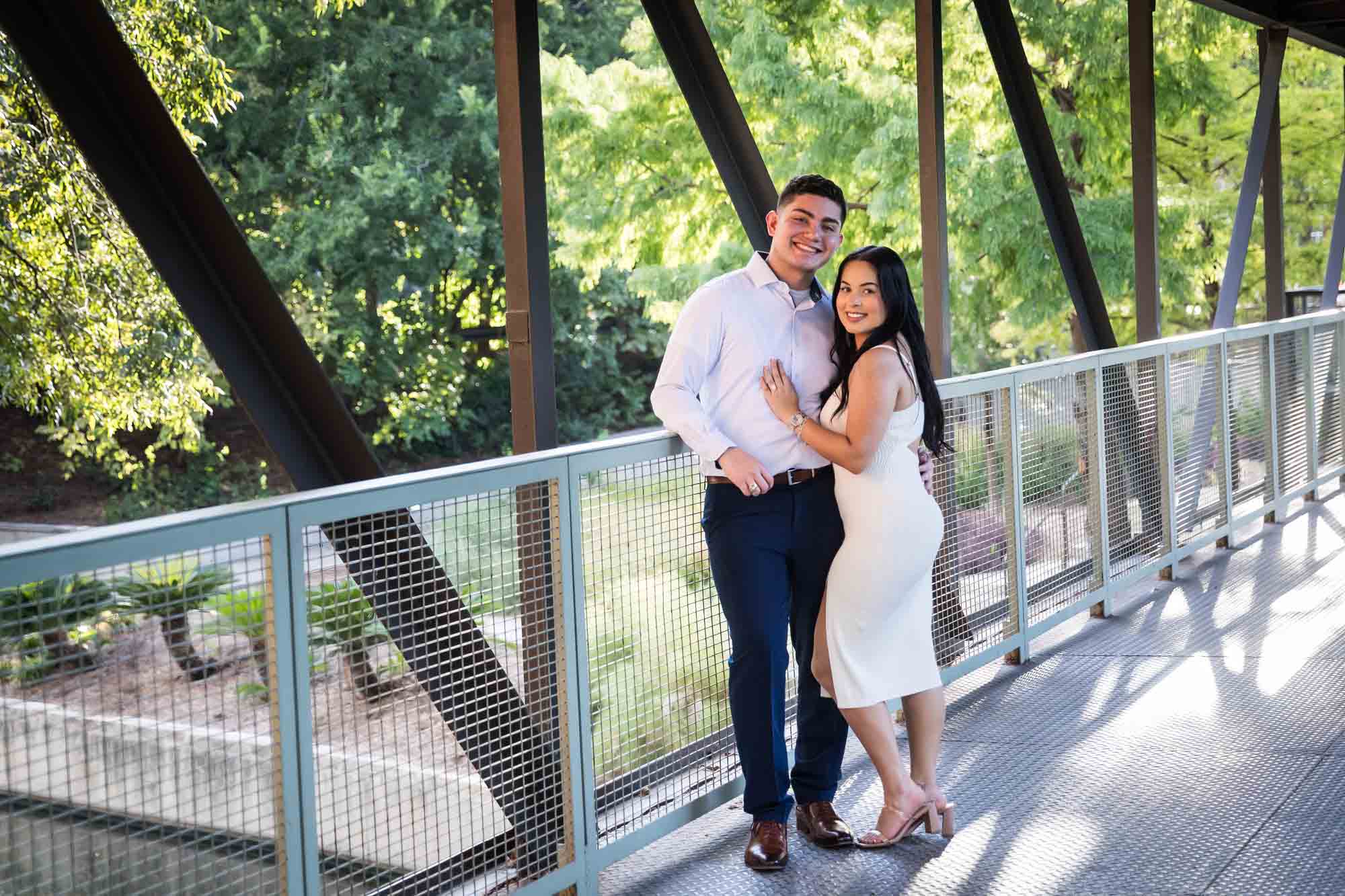 Couple hugging on covered bridge for an article on Pearl surprise proposal tips